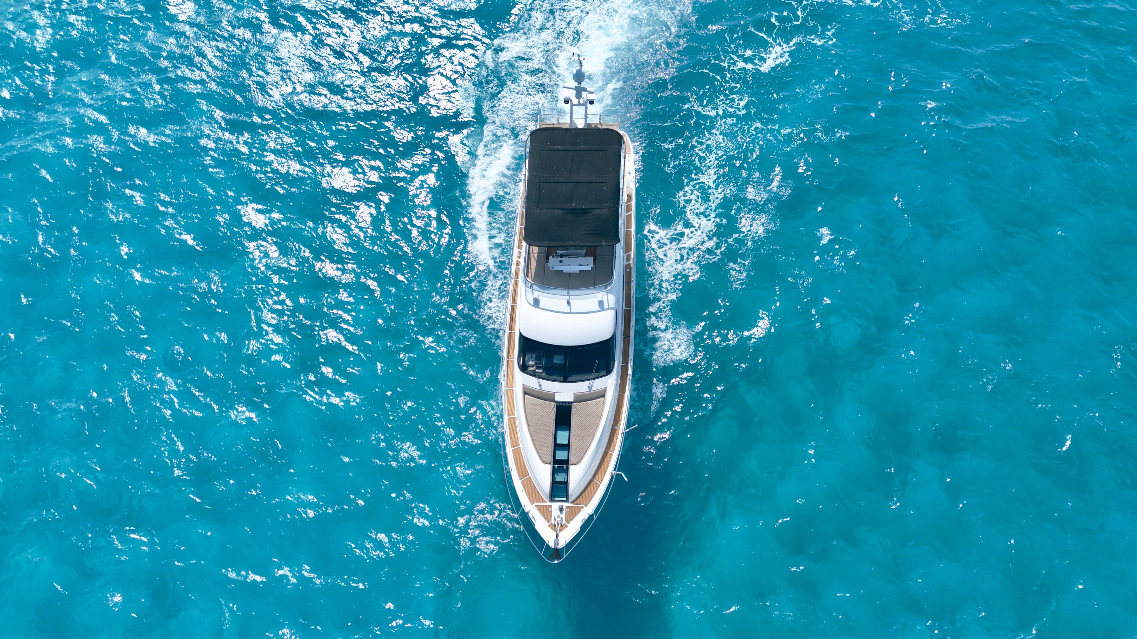 Top-down aerial view of Addicted under way with a white wake
