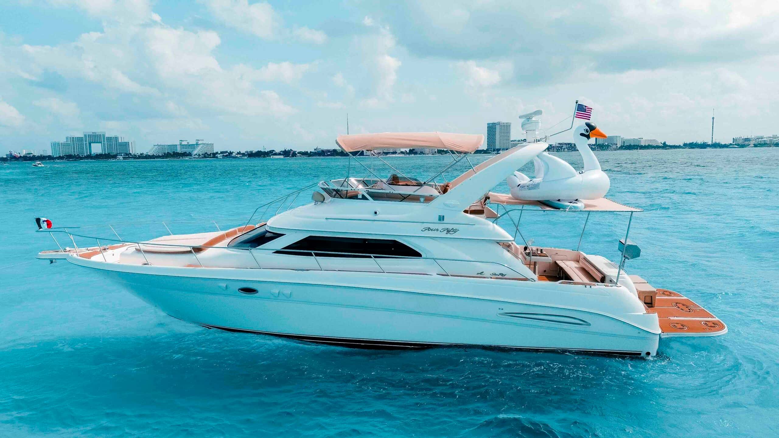 Side profile of Sea Monkey at anchor with the Cancun hotel zone behind