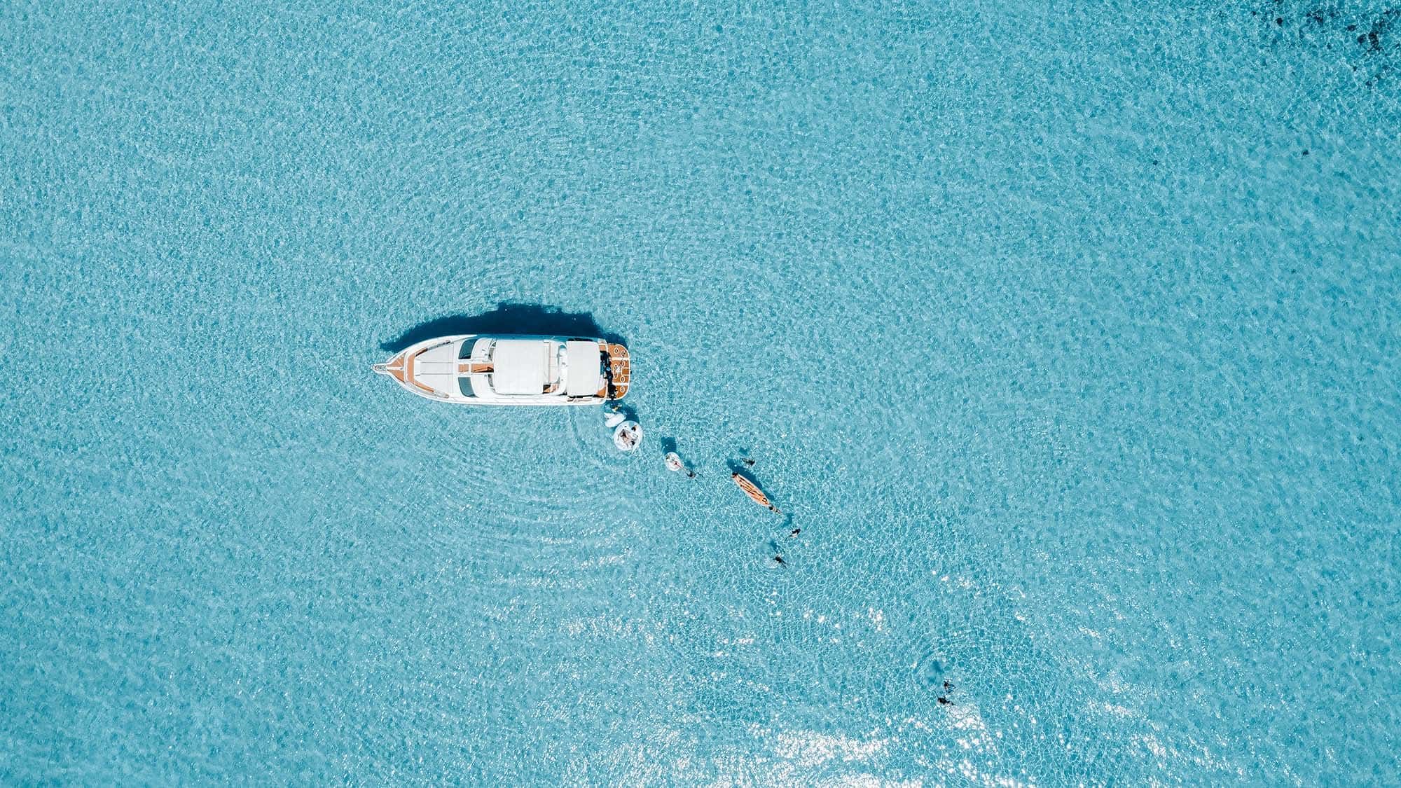 Aerial view of the boat at anchor with swimmers astern