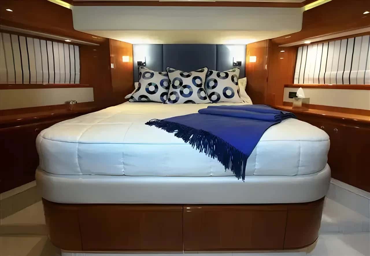 Forward queen cabin of another Ferretti 760 with a padded headboard and wood joinery