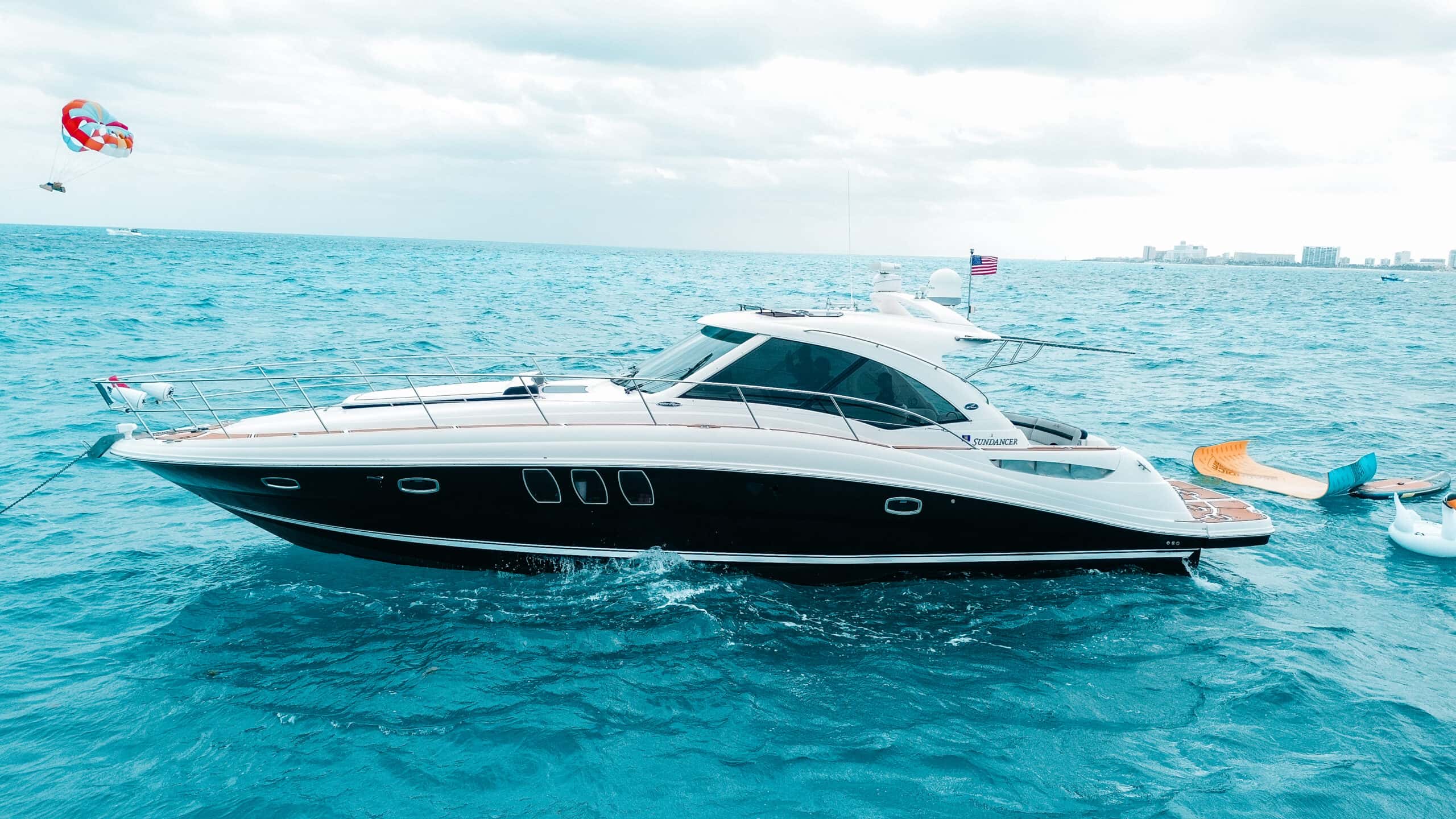 Sea Señor in full side profile at anchor with the Cancun hotel zone behind