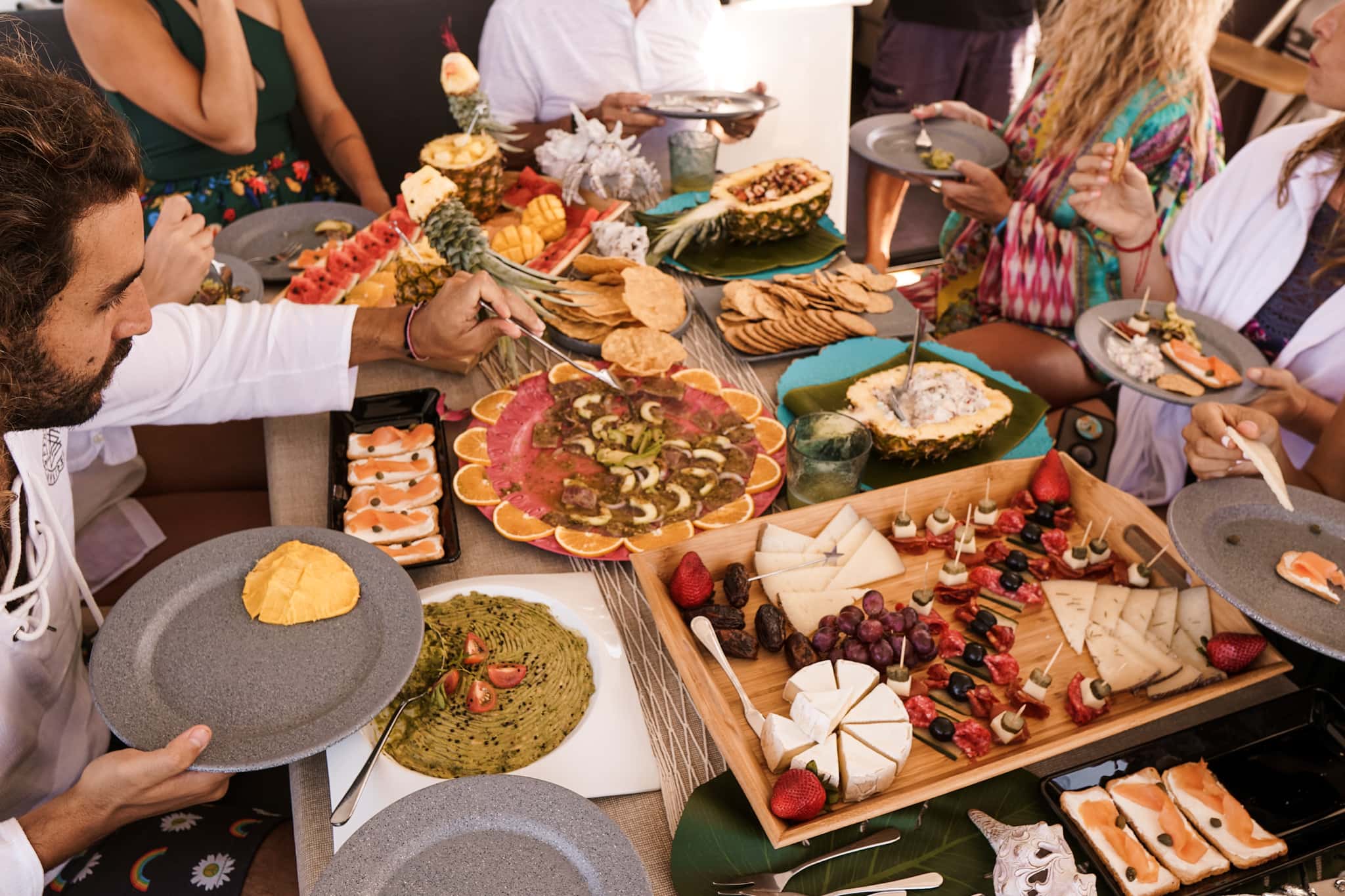 A spread on the cockpit table: aguachile, cheese and charcuterie, smoked salmon and guacamole