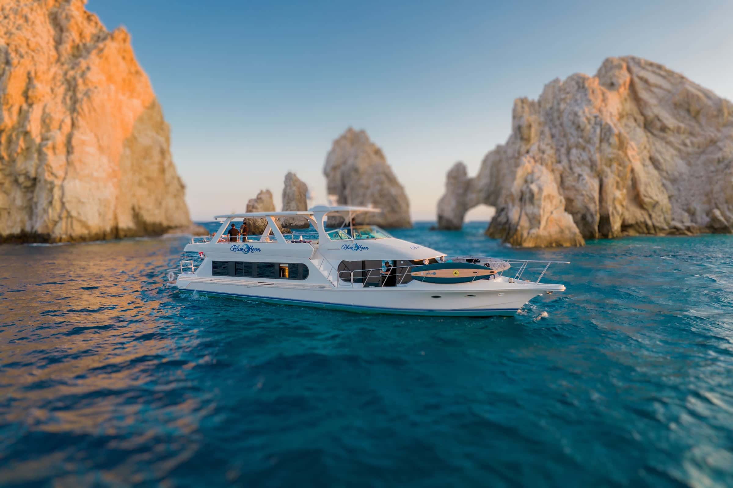 Blue Moon at golden hour below the arch and rocks of Land's End, Cabo San Lucas, seen from a drone