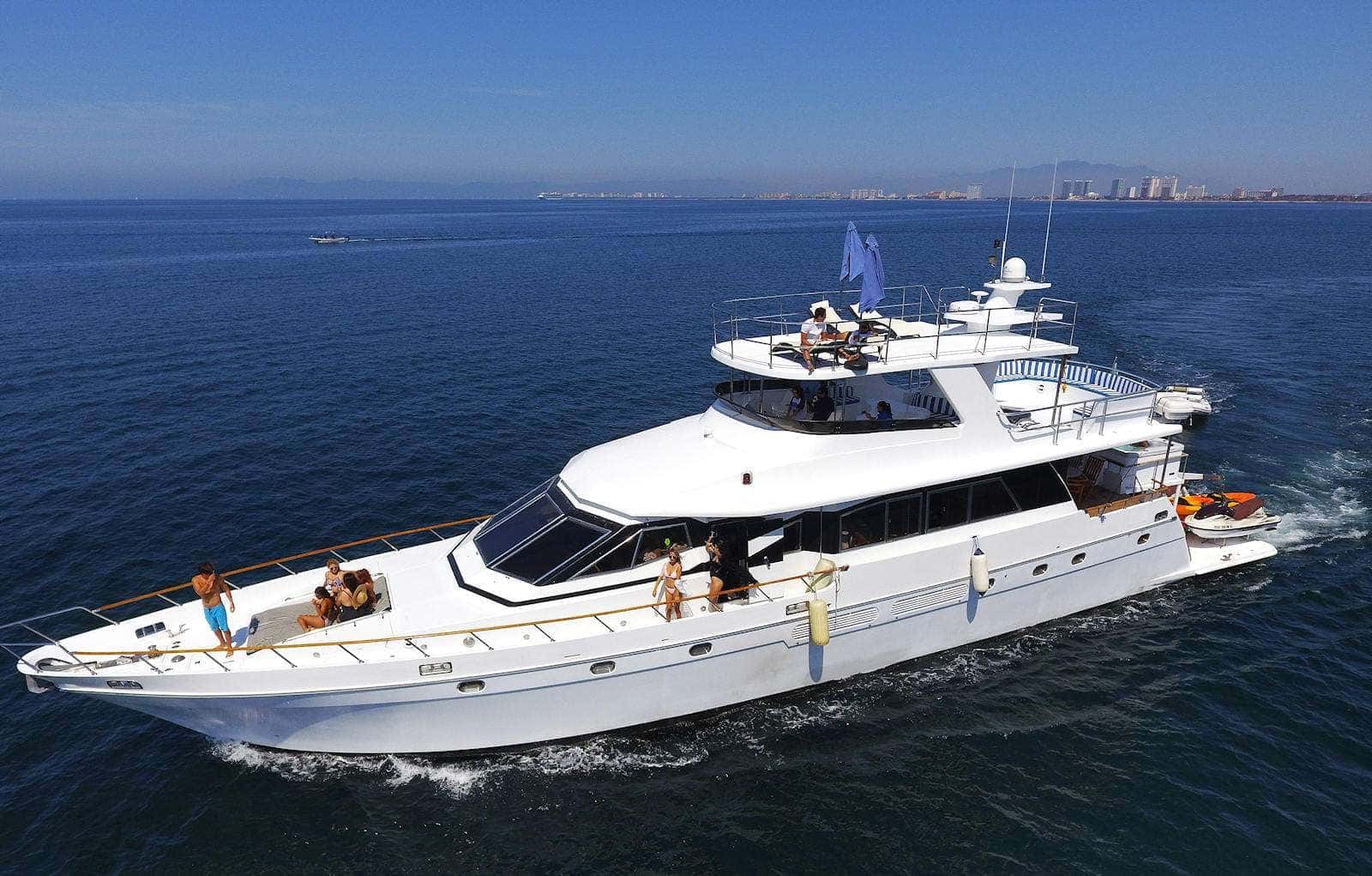 The yacht cruising seen from the air, guests on the foredeck and the sky deck