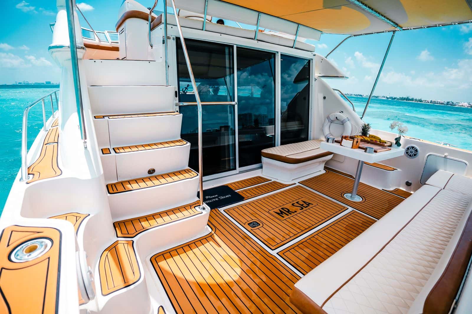Aft deck of Mr Sea with the stairs up to the flybridge, the sliding door to the salon and a side bench