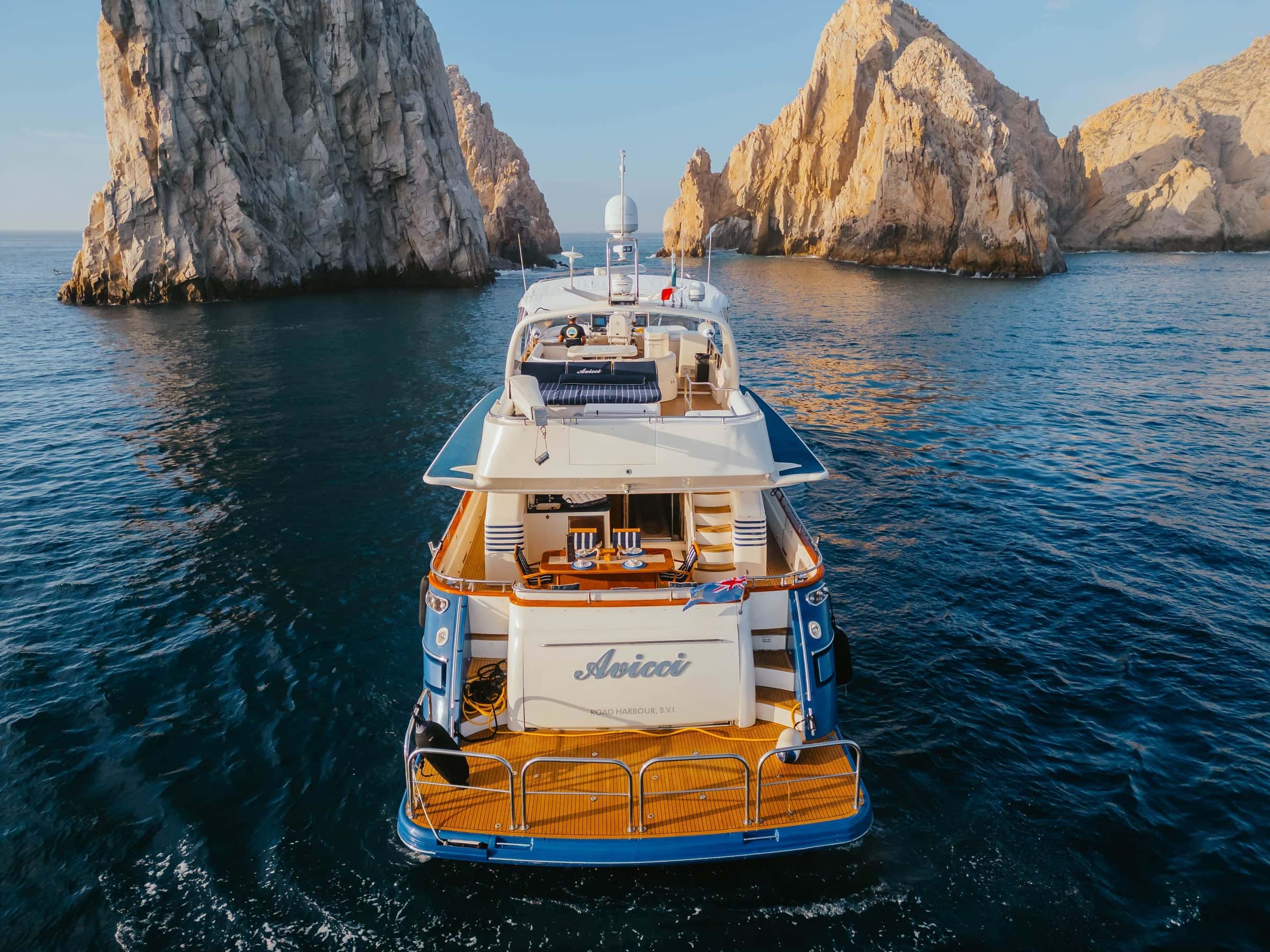 Avicci from astern, her name on the transom and the teak cockpit below the flybridge, the arch rocks ahead