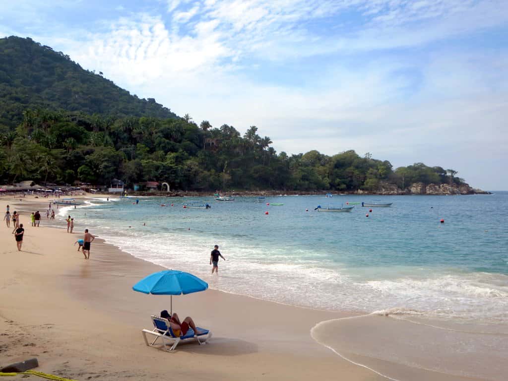 Mismaloya: the beach, small boats at anchor and the wooded hills behind