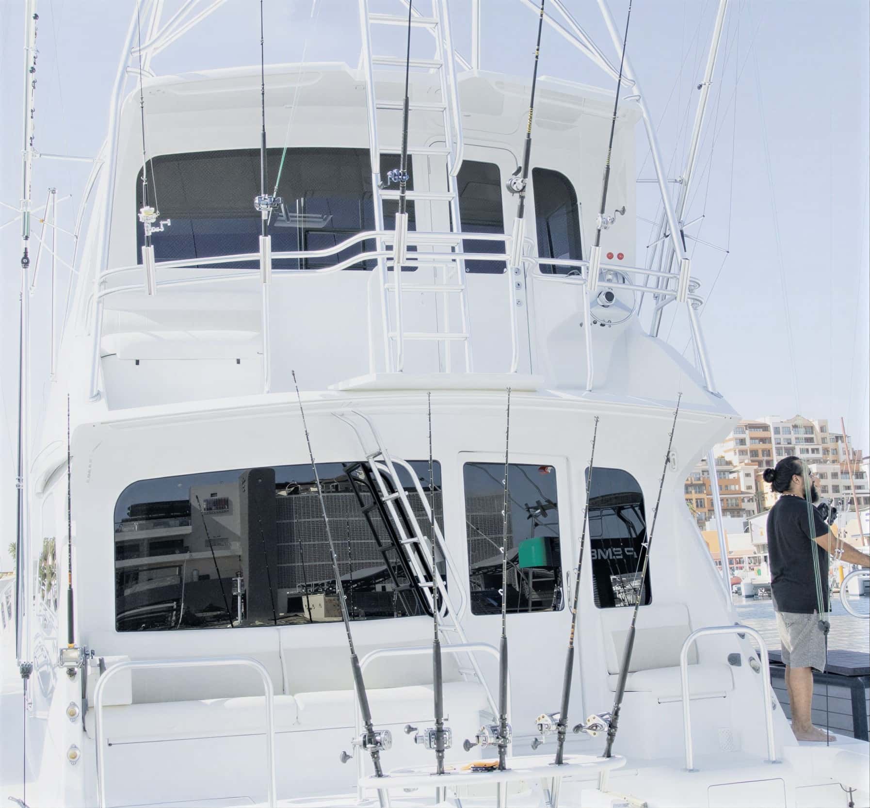 Fishing rods racked along the cockpit and bridge rails, seen from the stern at the dock