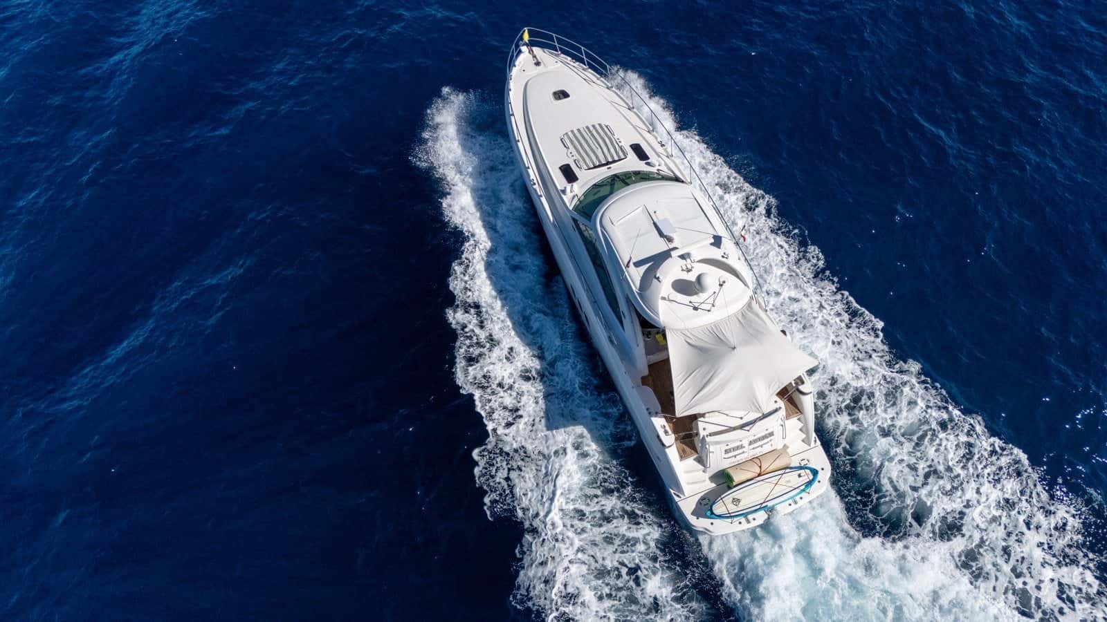 Aerial view from astern of the yacht under way, her foredeck sun pad and open sunroof seen from above
