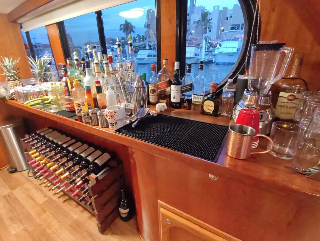 The saloon bar with bottles along the counter and a wine rack below