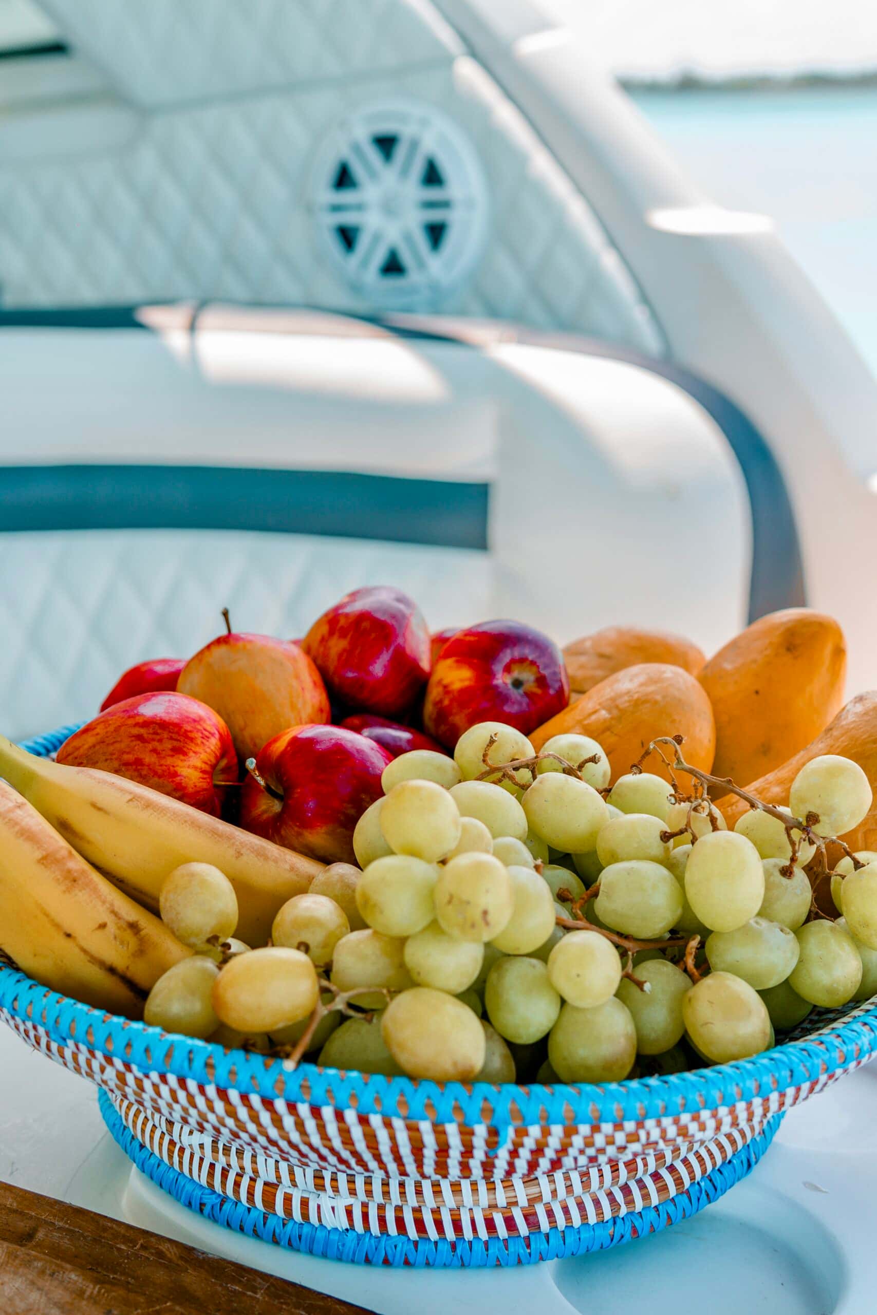 Fruit basket of bananas, grapes, apples and mangoes on board
