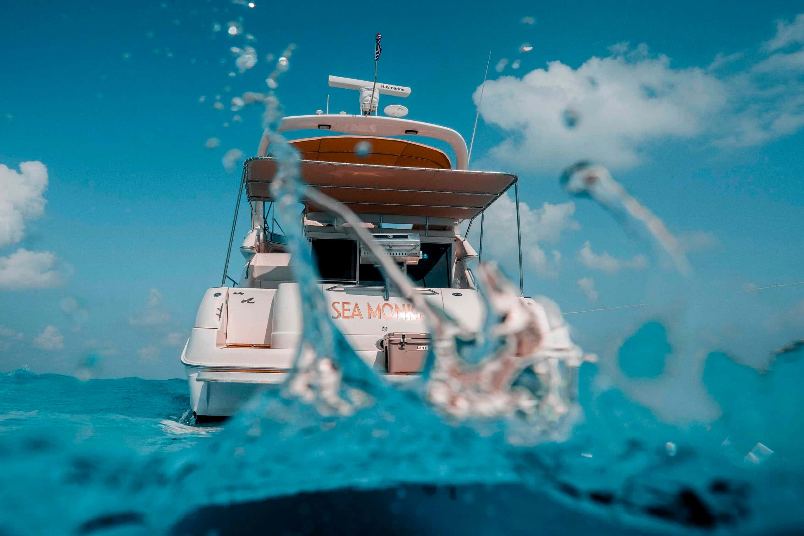 Stern of Sea Monkey from the waterline, with the name on the transom behind a splash