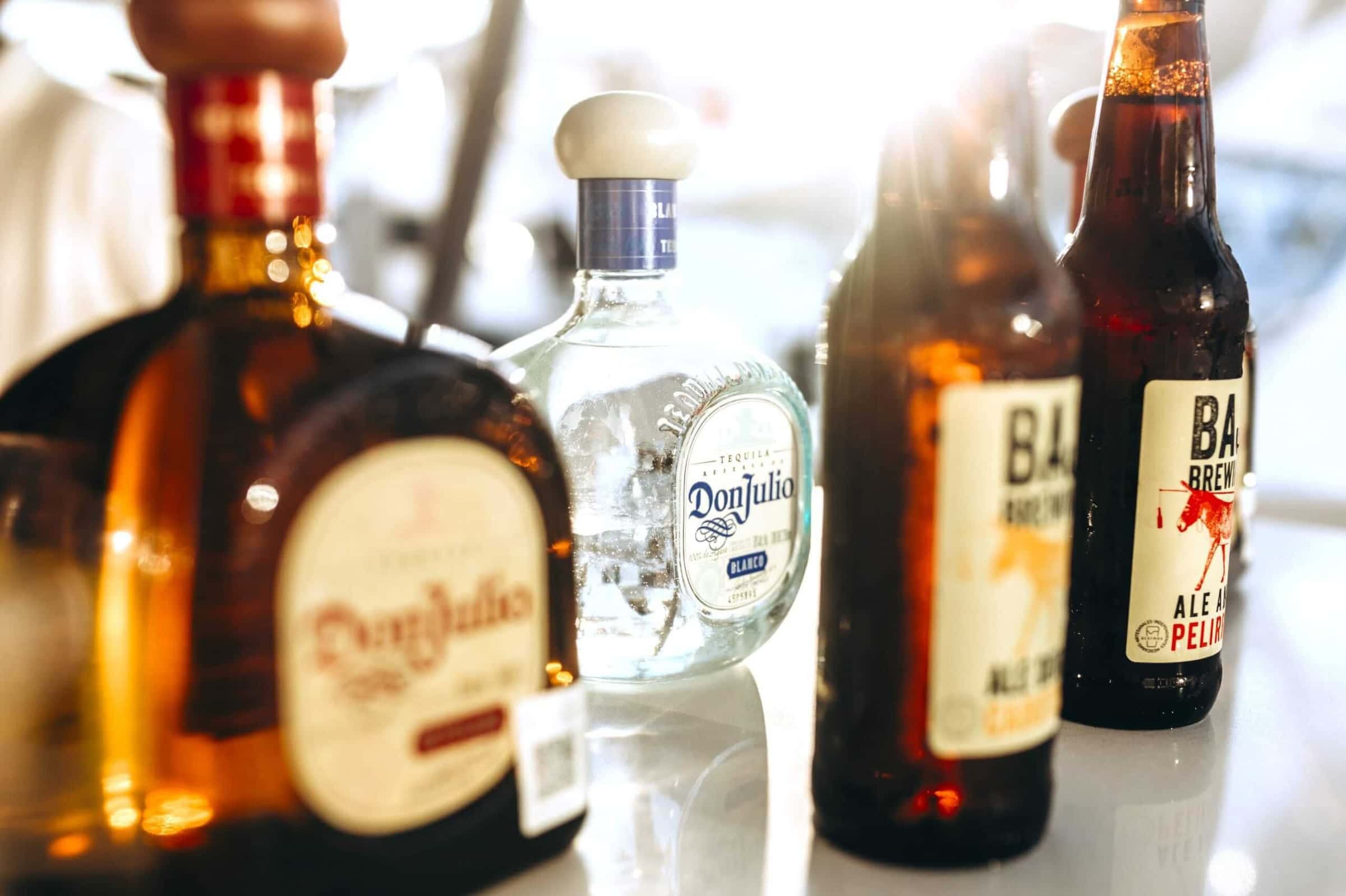 Bottles of tequila and craft beer lined up on the bar