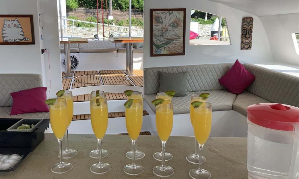 A row of orange drinks with lime on the saloon counter, the lounge behind