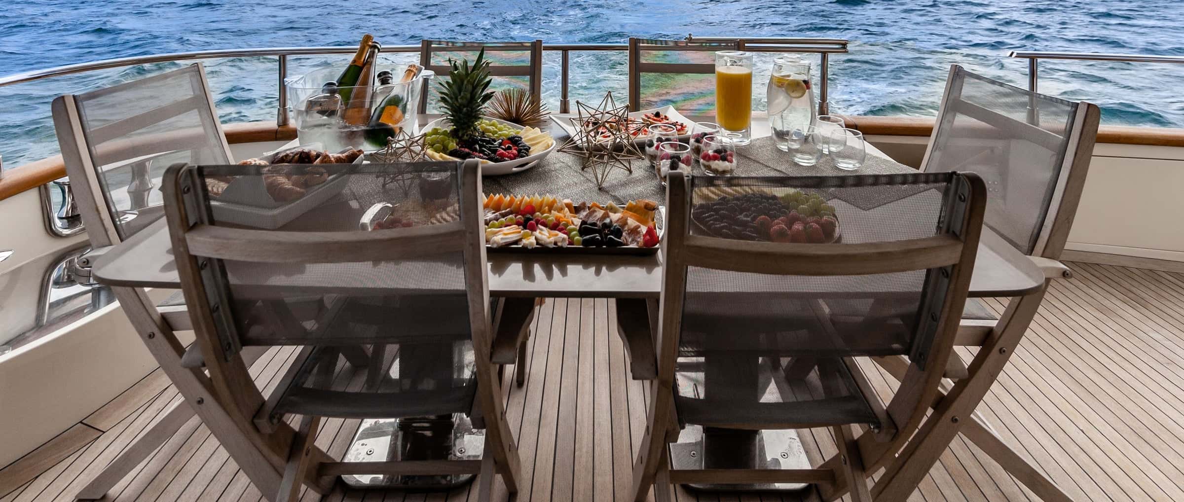 Platters of fruit, cheese and snacks on the aft deck table, with juice and sparkling wine