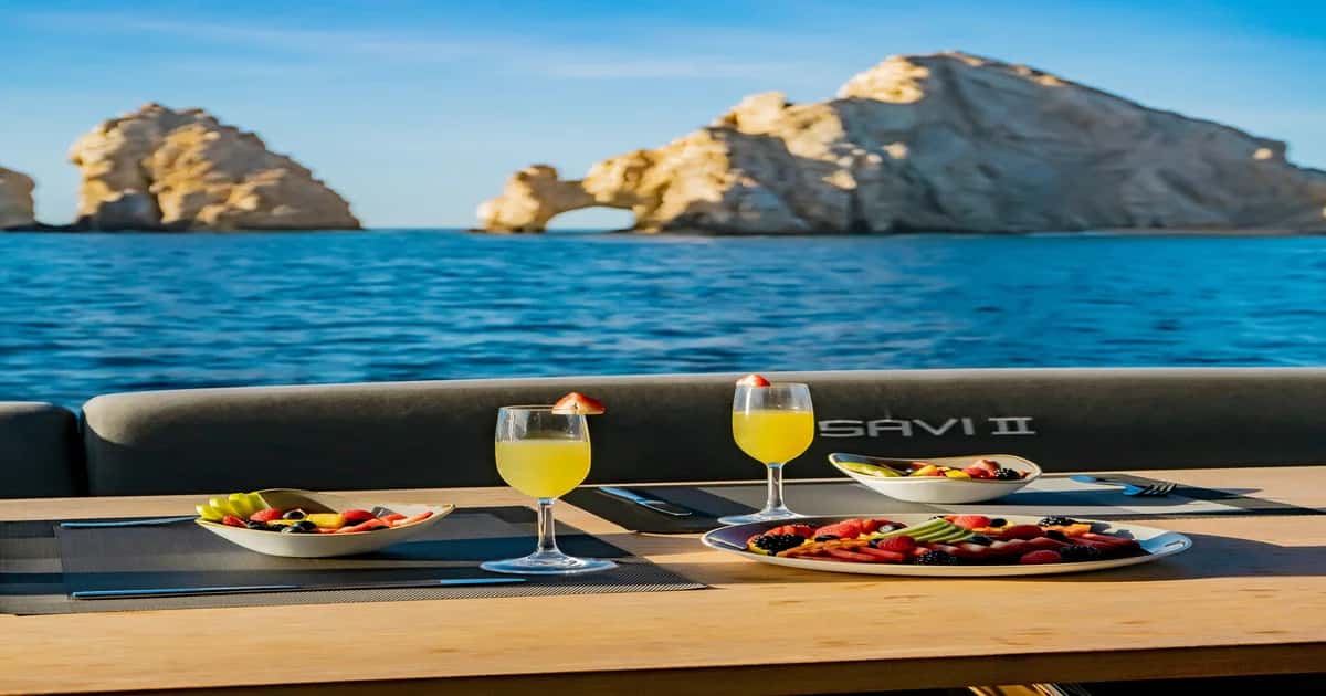 Fruit plates and two juices on the flybridge table facing the arch