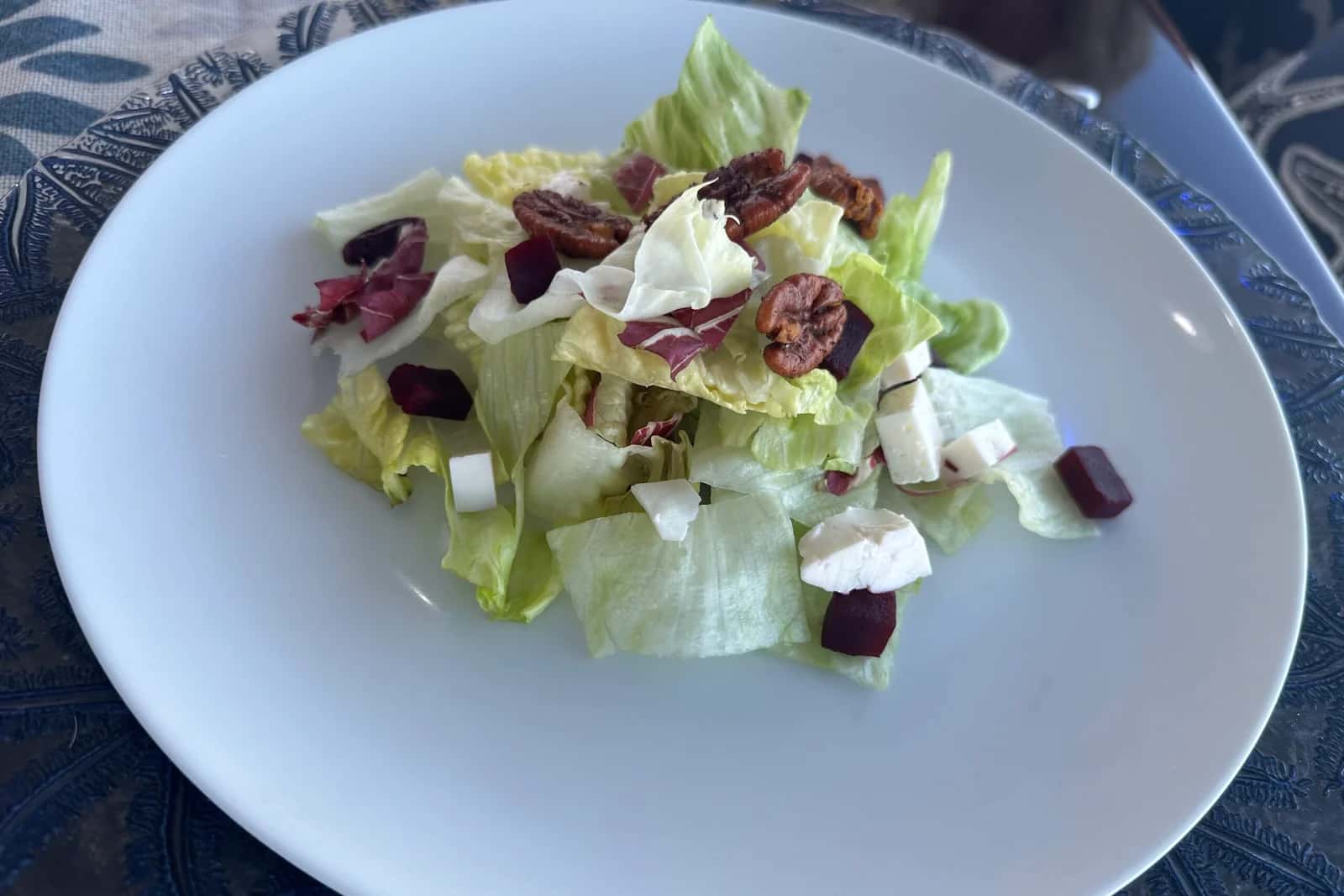 Plated green salad with beetroot, cheese and candied nuts