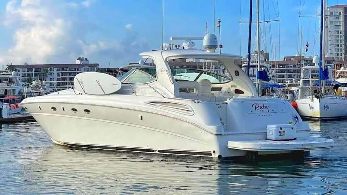 Stern of the white yacht Ruby with a swim platform and cooler, moored in a marina