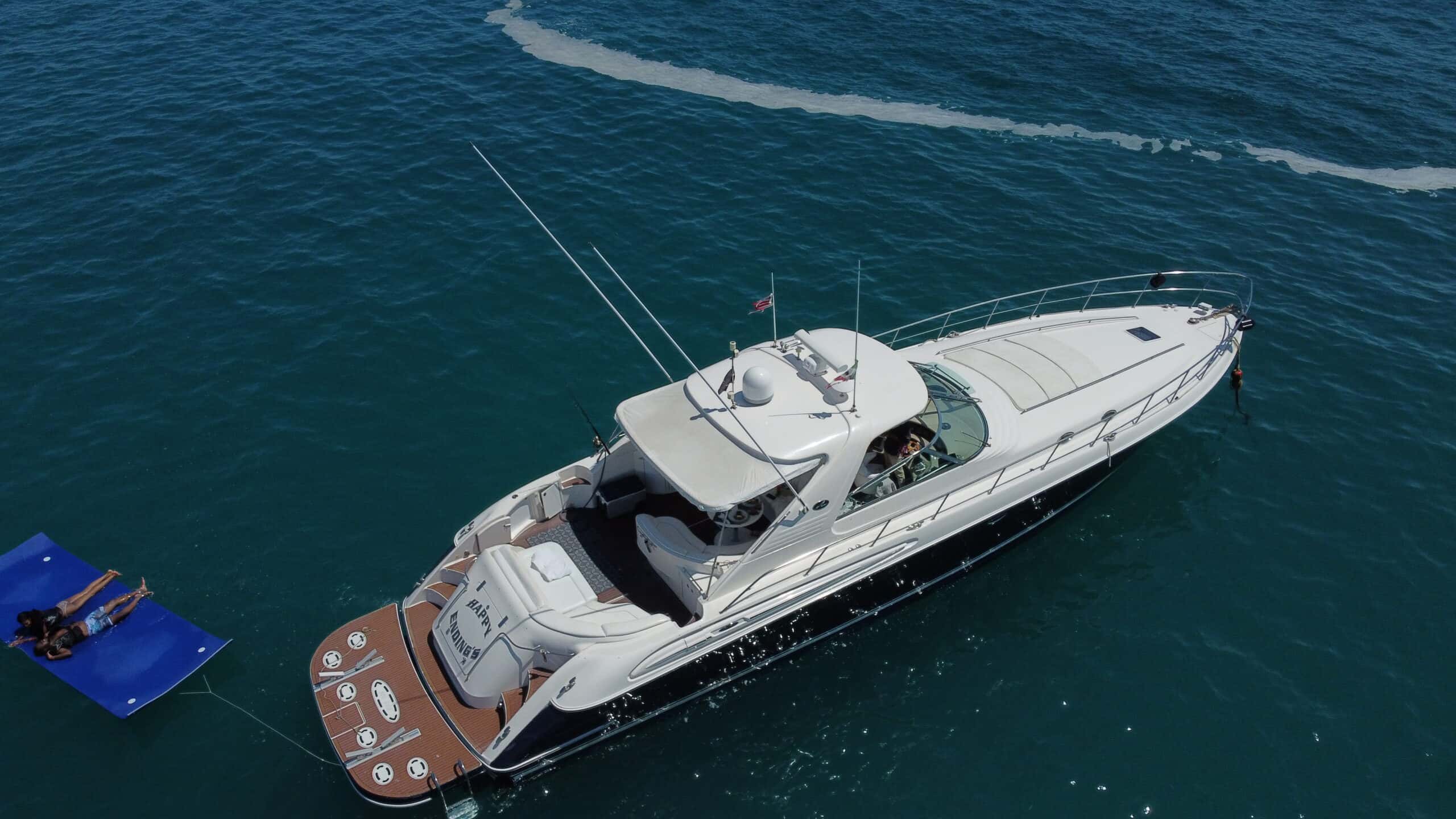 Aerial view of the Happy Ending from astern, with its teak swim platform and a blue floating mat towed alongside