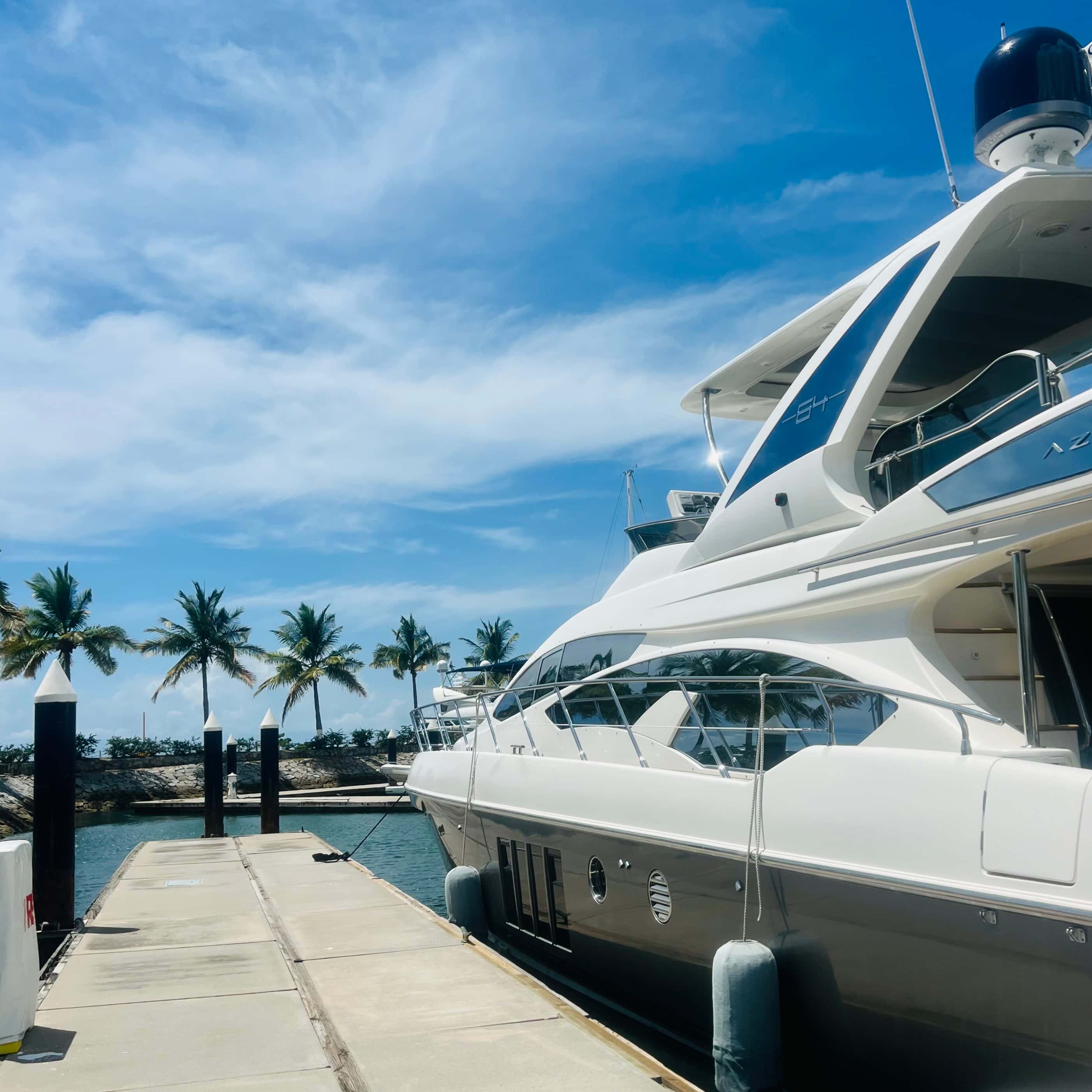 Alterego, a white Azimut yacht, moored along a marina dock, palm trees behind