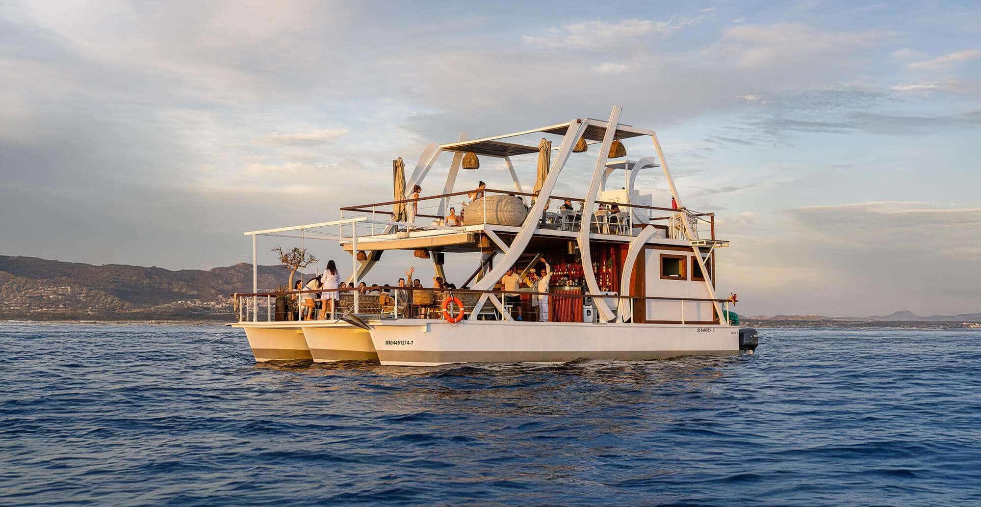 Pelican 11 catamaran at sea at golden hour with guests on both decks