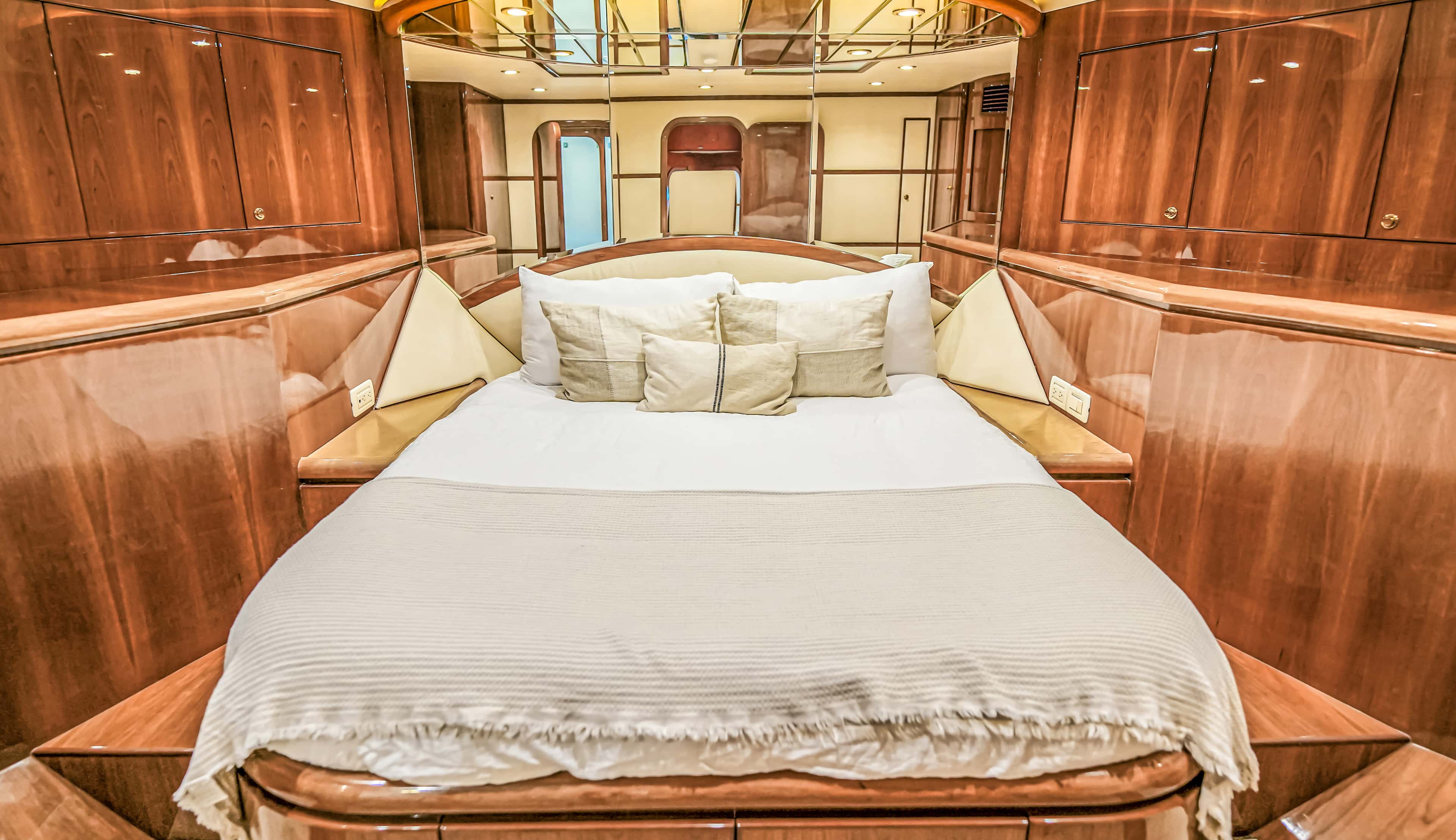 VIP cabin with a queen bed and a mirrored ceiling panel, seen from a low angle