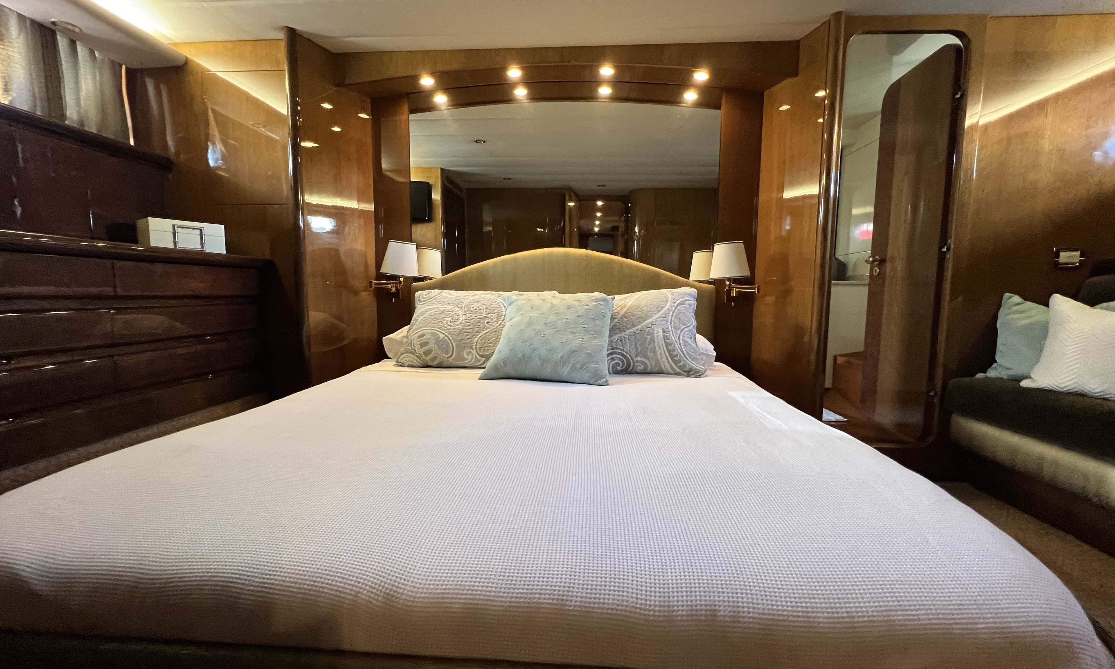 Master stateroom with a walk-around bed, burl wood joinery and a sofa