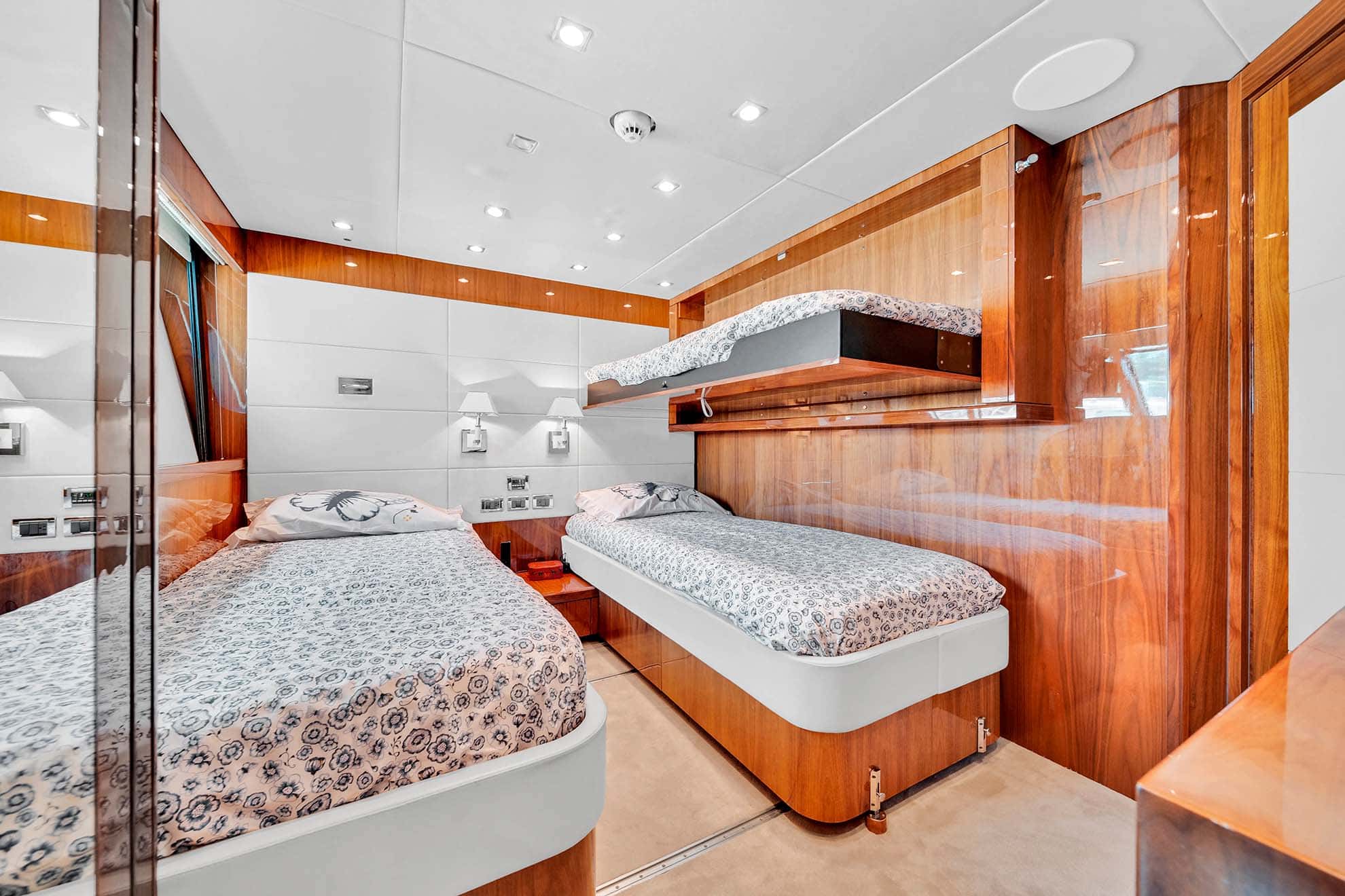Twin cabin with two single beds and a fold-down upper berth opened above one of them