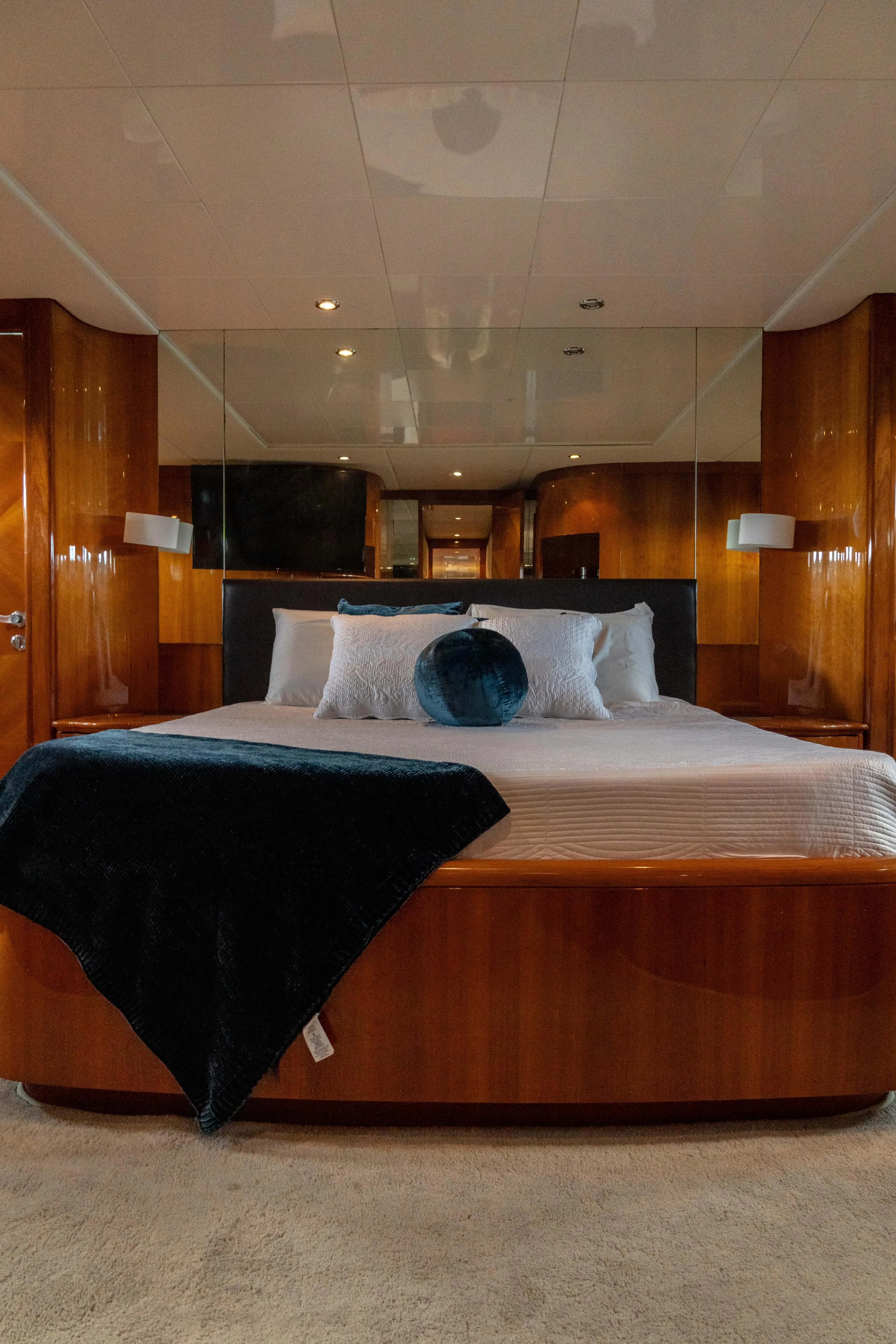 The master cabin's king bed, set against a mirrored bulkhead