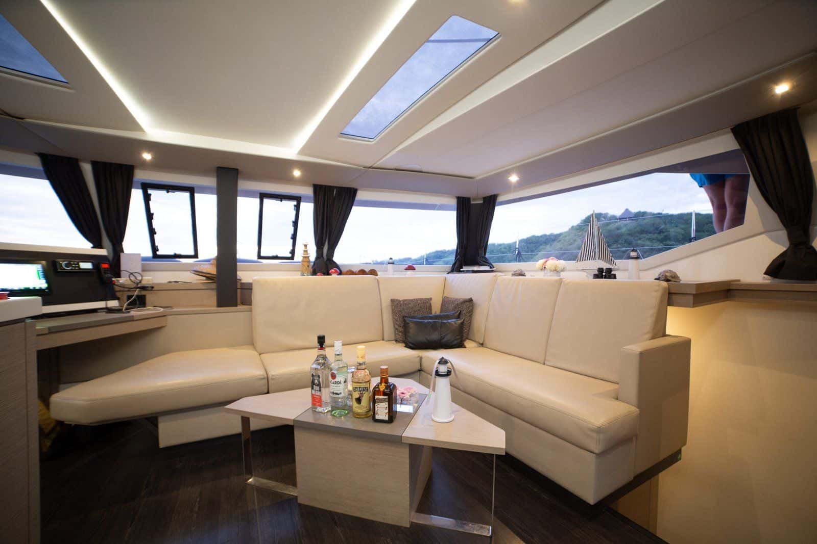 Saloon with a cream corner sofa and coffee table under skylights, wraparound windows on the bay