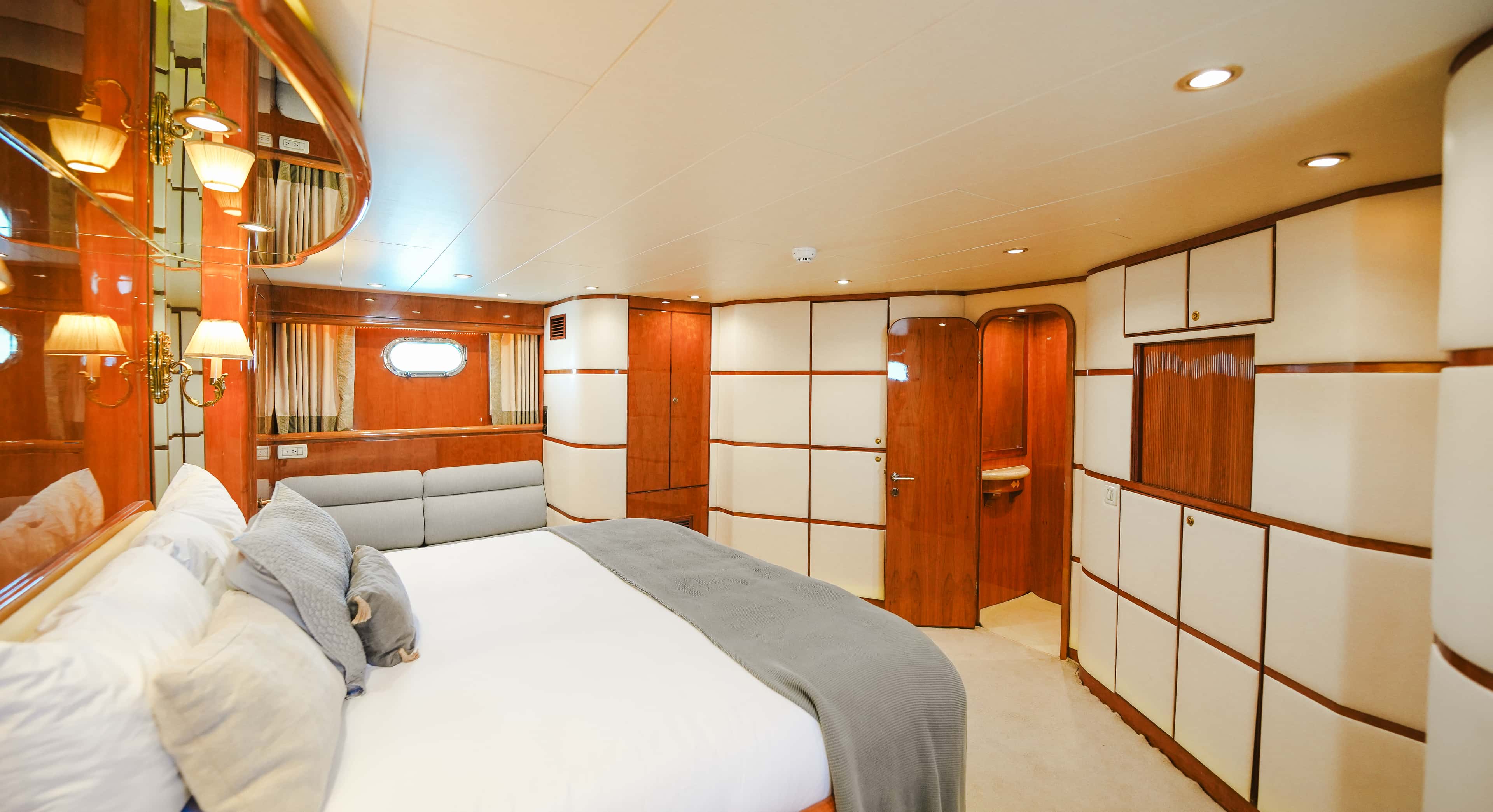 Master cabin with a white panelled wardrobe wall, seen from the far side of the bed