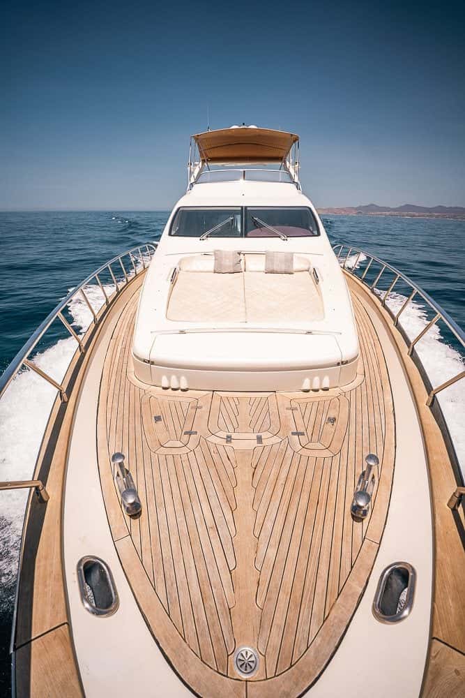 Looking aft over the teak foredeck and its sun pads to the windscreen and flybridge, under way