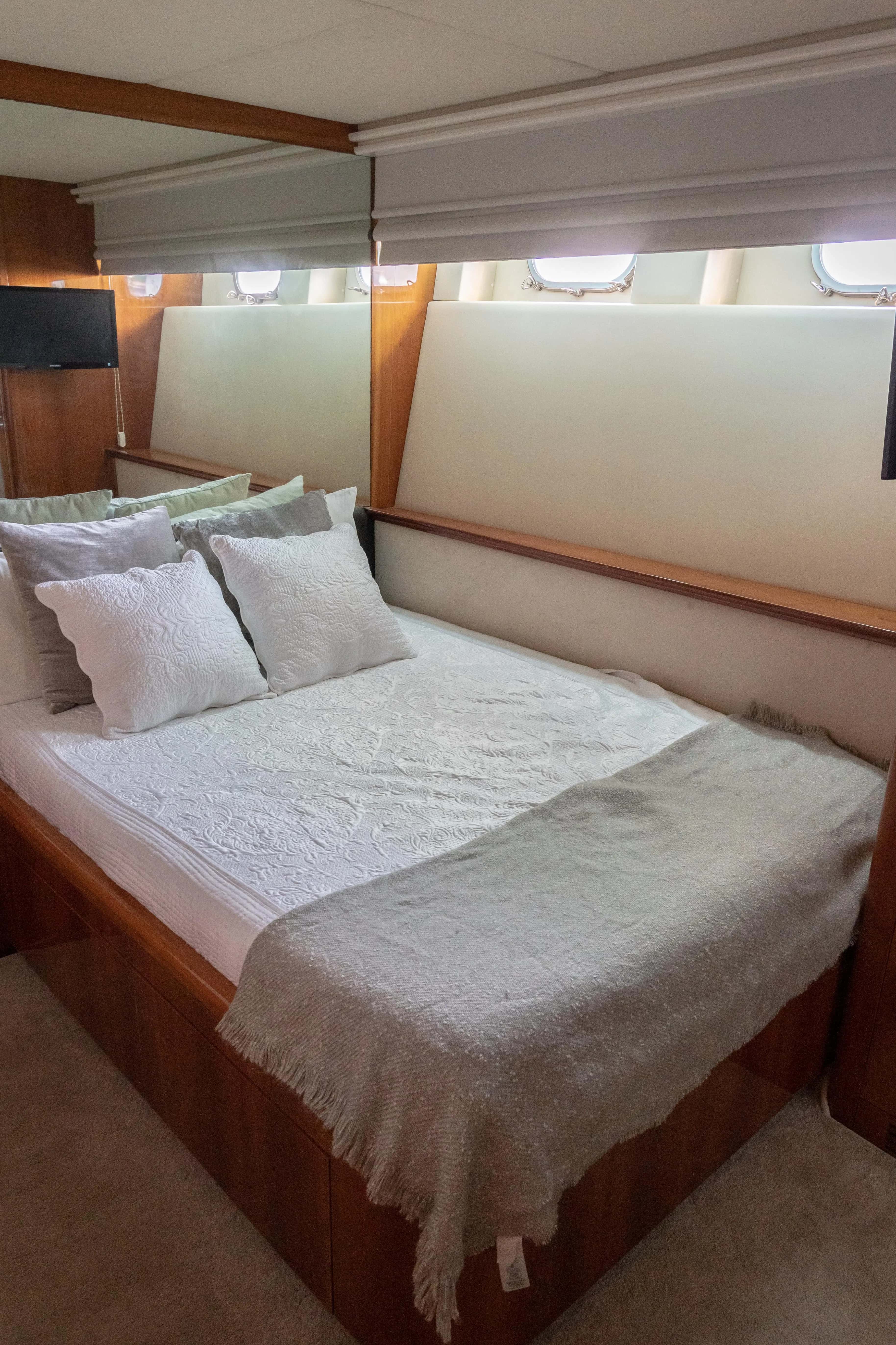 A queen cabin with portholes above the bed