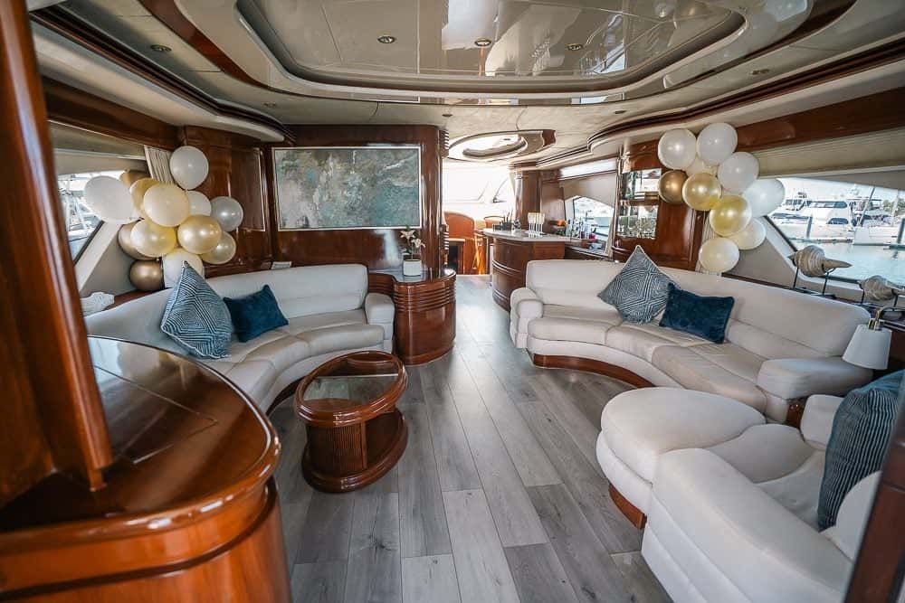 Saloon with two curved white sofas facing over a low table, wood joinery and balloons for a party
