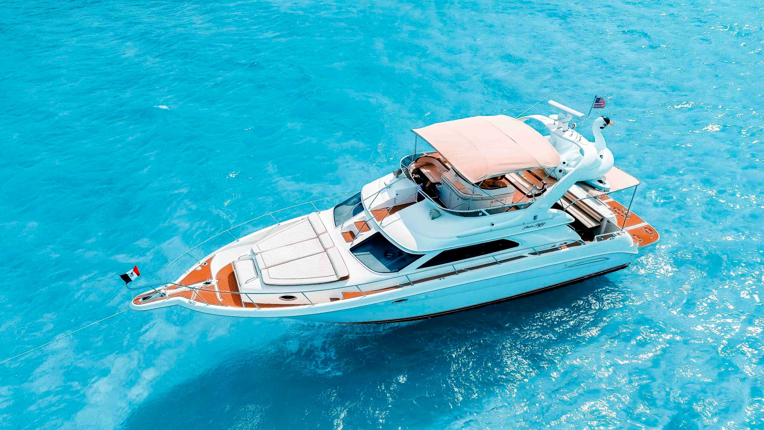 Aerial view of Sea Monkey at anchor from the bow quarter, with the flybridge, bimini and swan floats