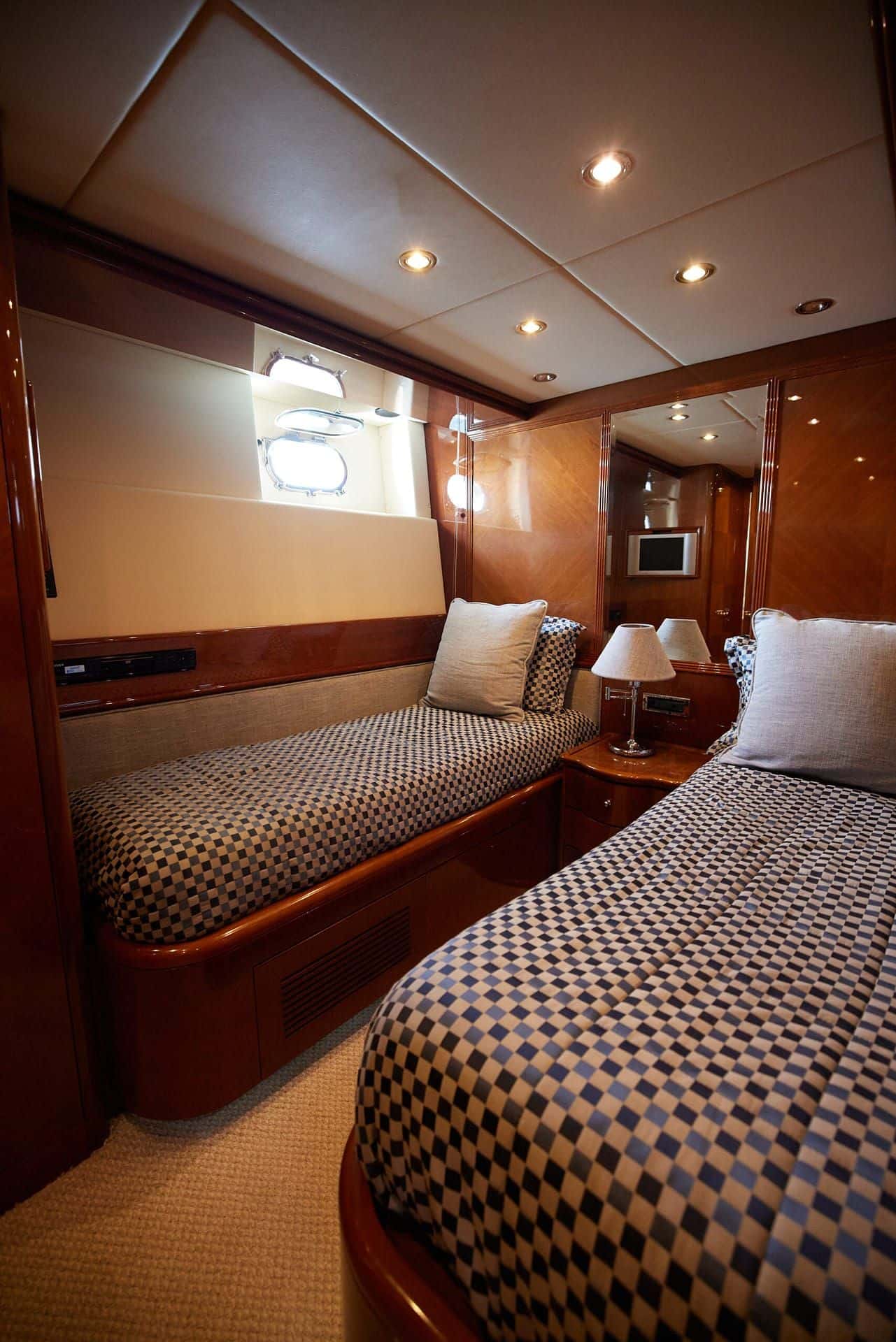 Twin cabin with two single beds along the hull and a porthole above