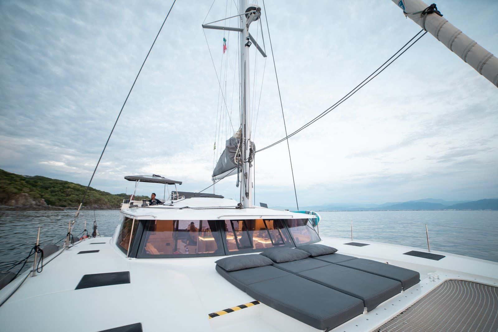 Grey sunpads on the foredeck, looking aft to the saloon windows and the flybridge