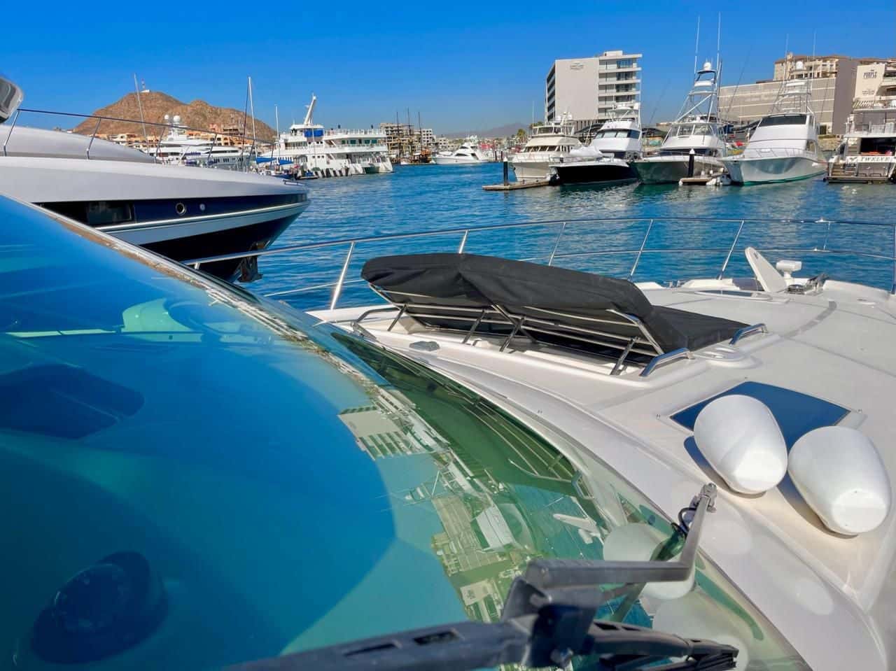 Foredeck sun pad behind the windscreen, the marina and the town of Cabo San Lucas beyond