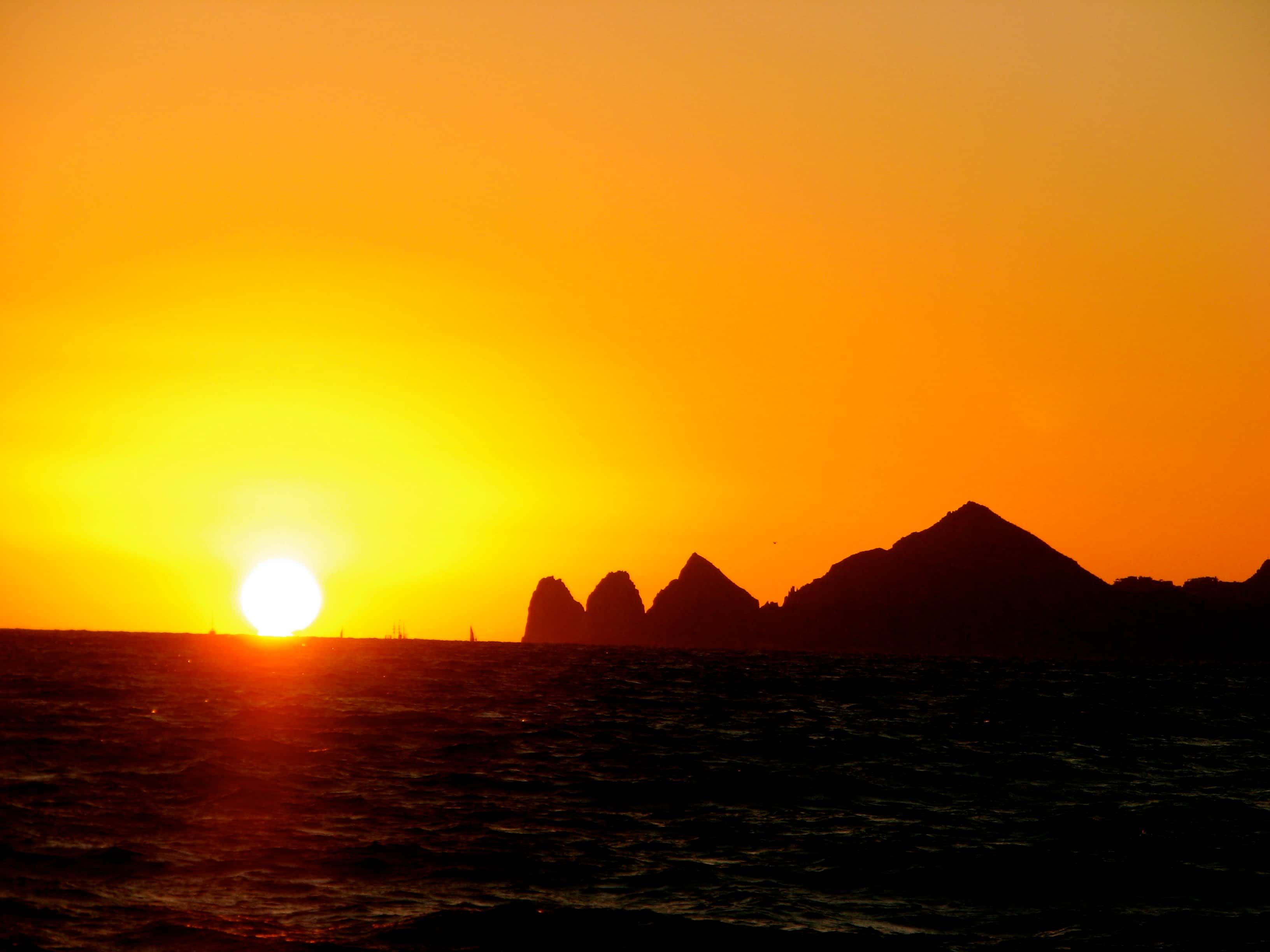 Cabo San Lucas: the sun setting over the sea, Land's End rocks in silhouette