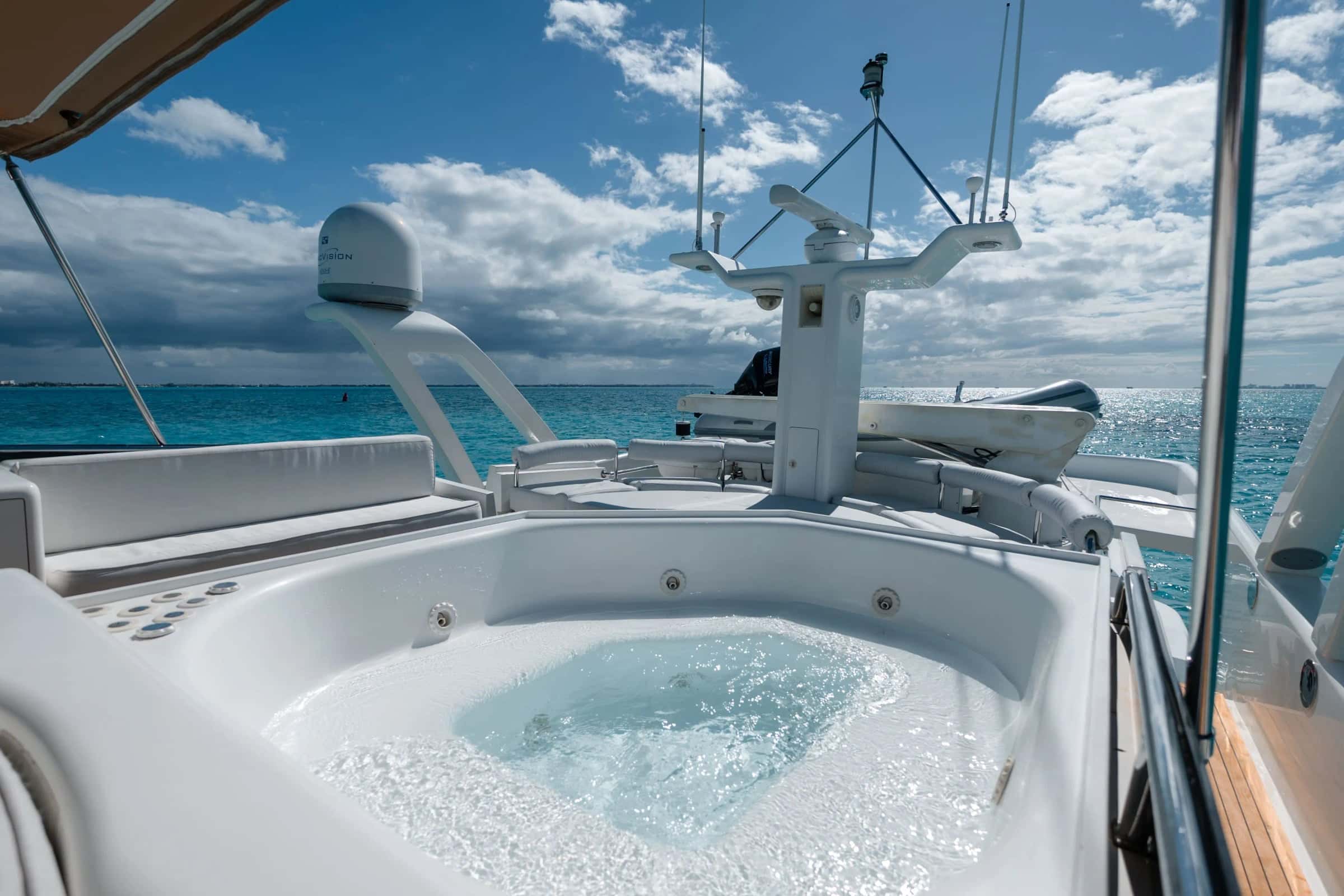 The Jacuzzi on the flybridge, bubbling, with white seating around it and the radar arch behind
