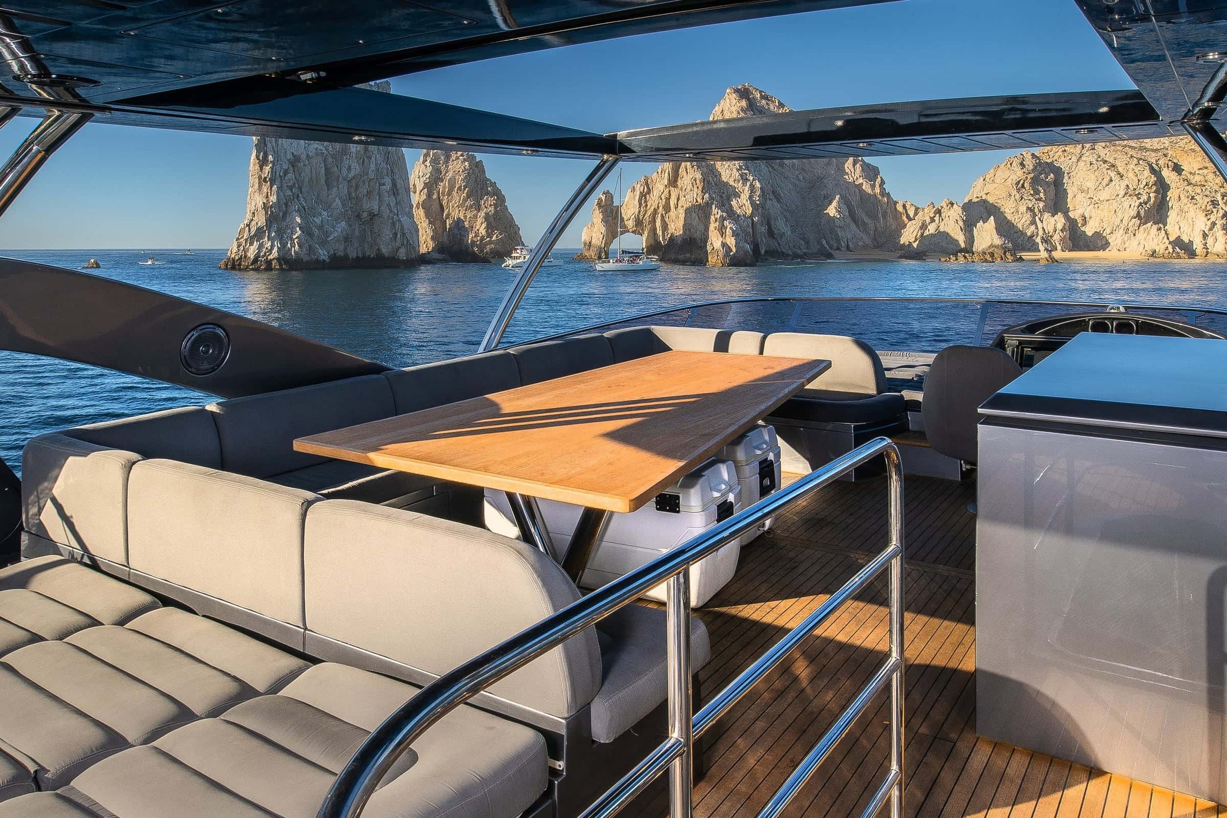 Flybridge seating and table under the hardtop, looking out at the rock arch