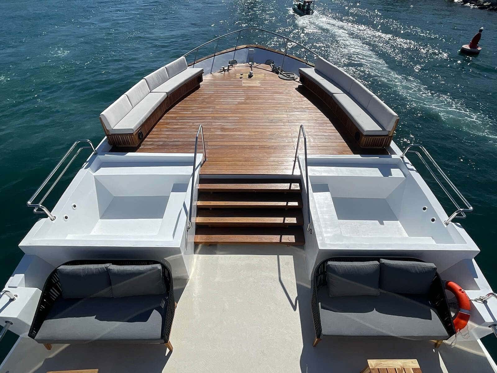 Two plunge pools on the bow deck, sofas and steps down to the teak foredeck