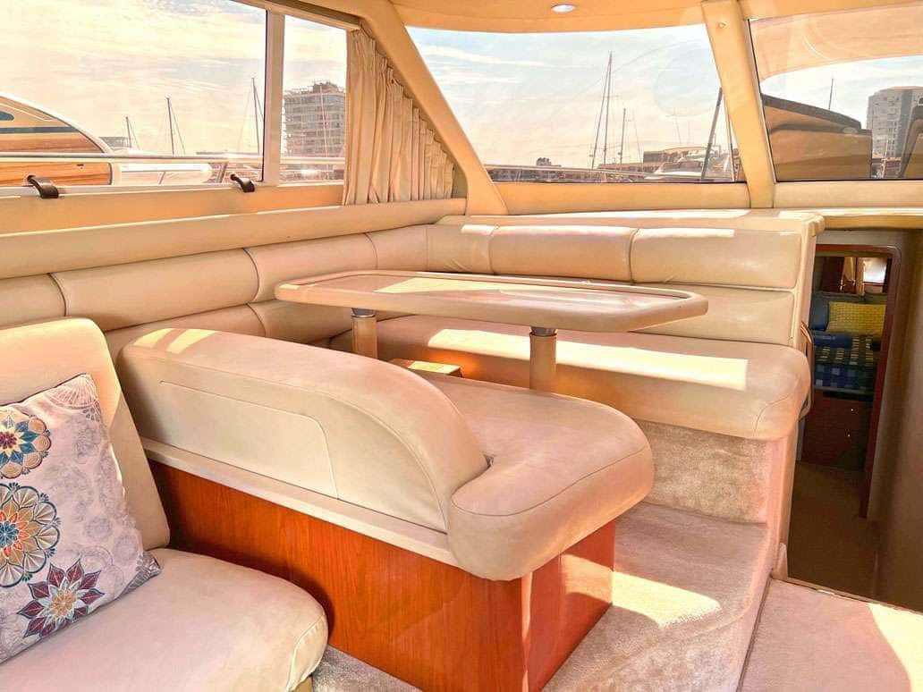 Dinette with a cream U-shaped seat and a table beside the saloon windows