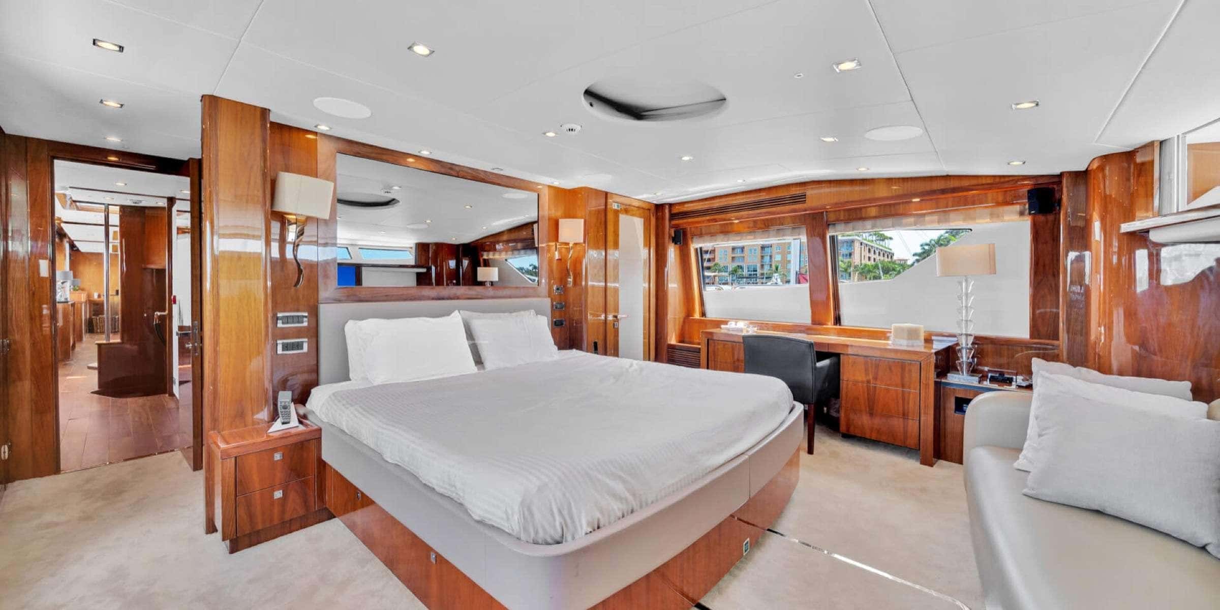 Master cabin with a double bed, desk, sofa and wood panelling