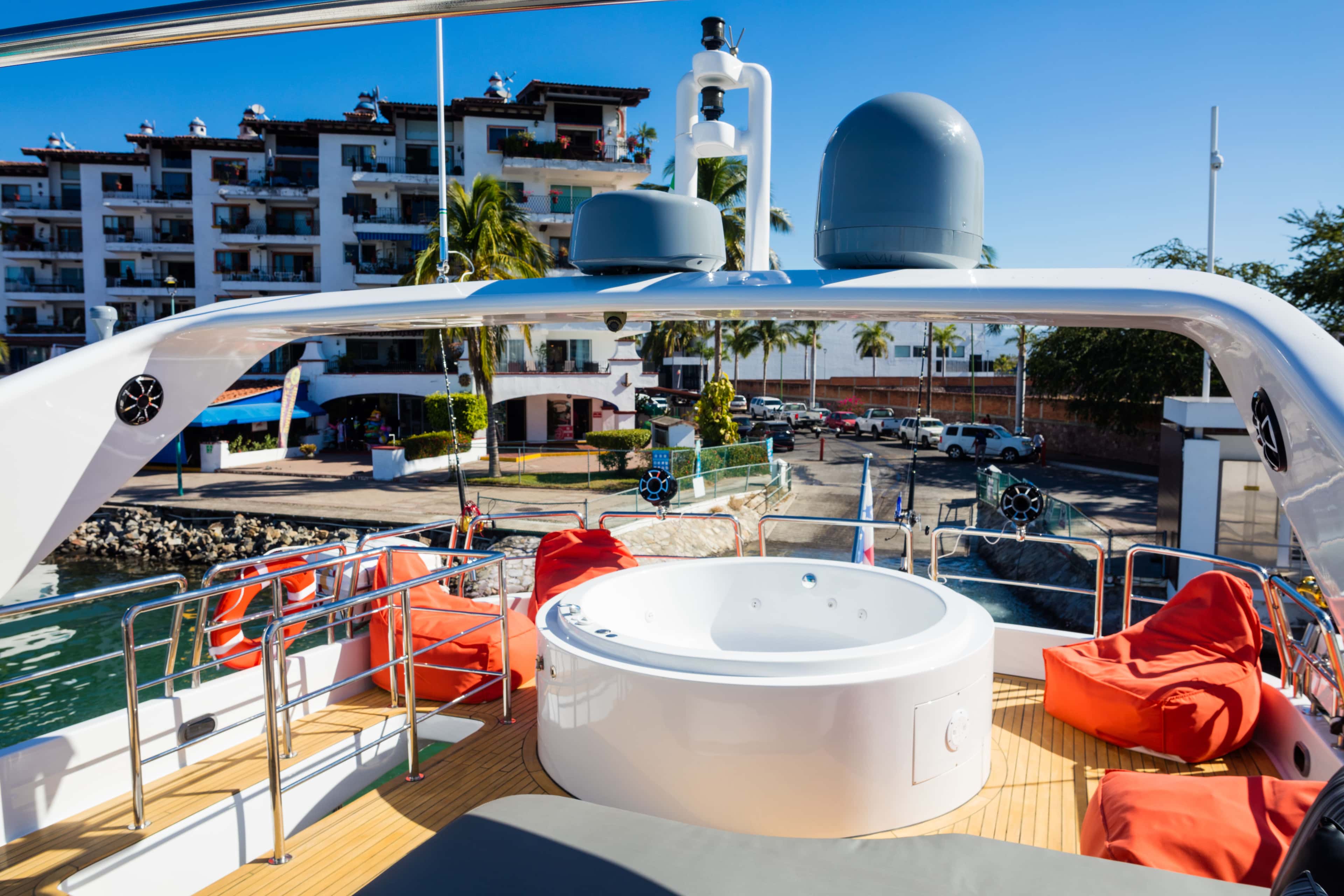 Flybridge with a round jacuzzi, orange bean bags and a lifebuoy