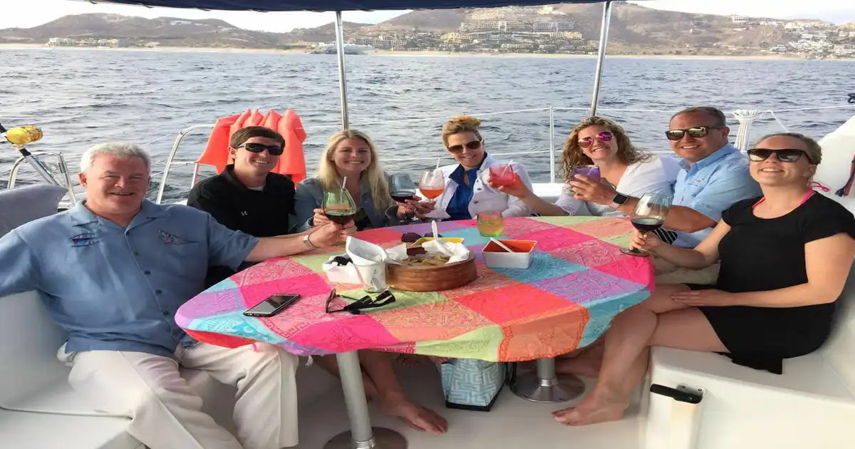 Six guests with drinks around a colourful table under the blue bimini