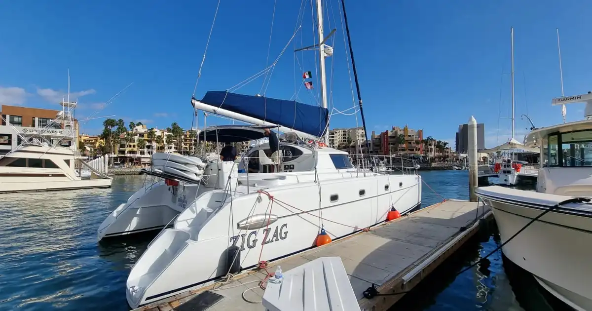 Zig Zag catamaran moored at a marina dock under a blue sky