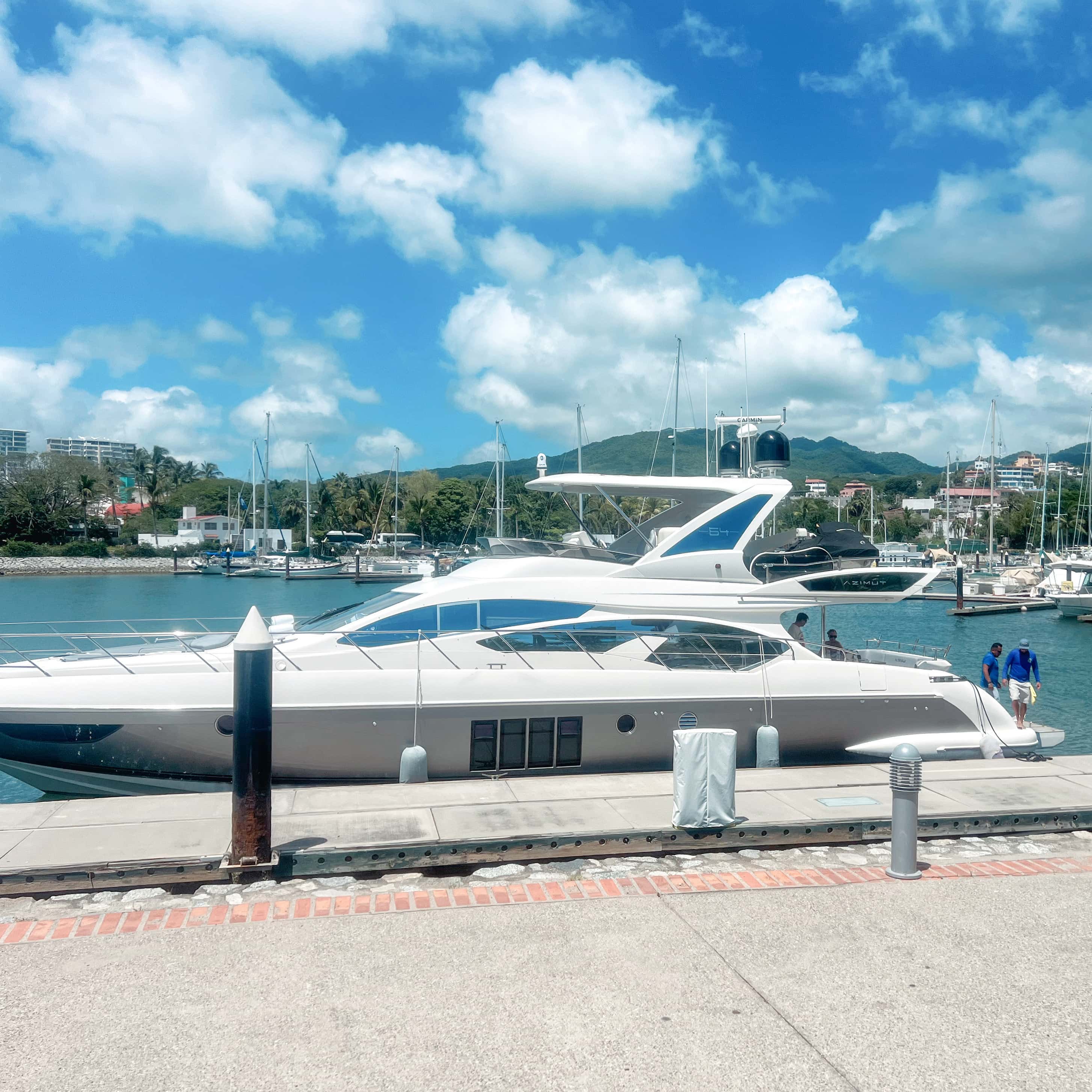 Alterego, a white Azimut 64 flybridge yacht, moored at a marina dock under a blue sky